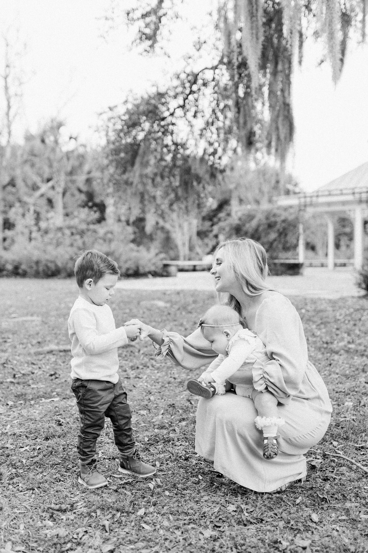 Black and white image of Mom with two kids in Charleston SC. Photo by Caitlyn Motycka Photography.