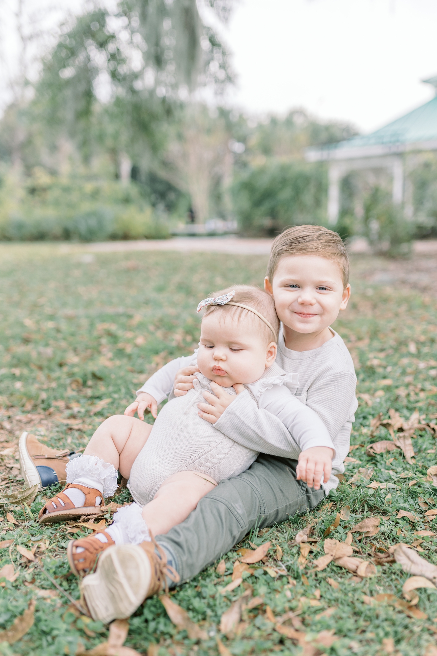 Baby sitting on big brother's lap during family photoshoot in Charleston, SC. Photo by Caitlyn Motycka Photography.