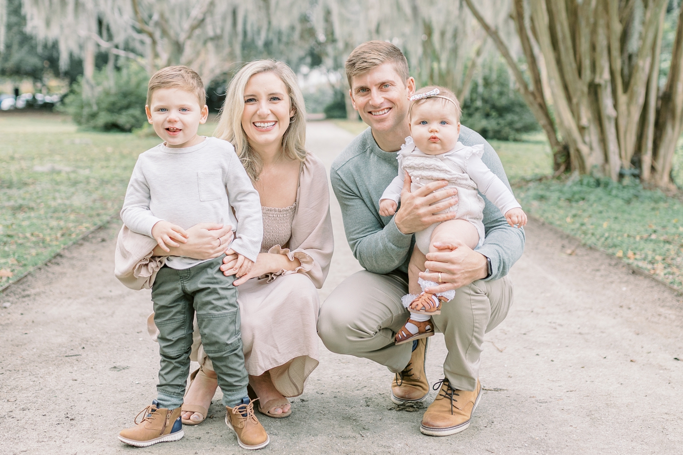 Sweet family with two kids smiling at the camera during session in Charleston SC. Photo by Caitlyn Motycka Photography.