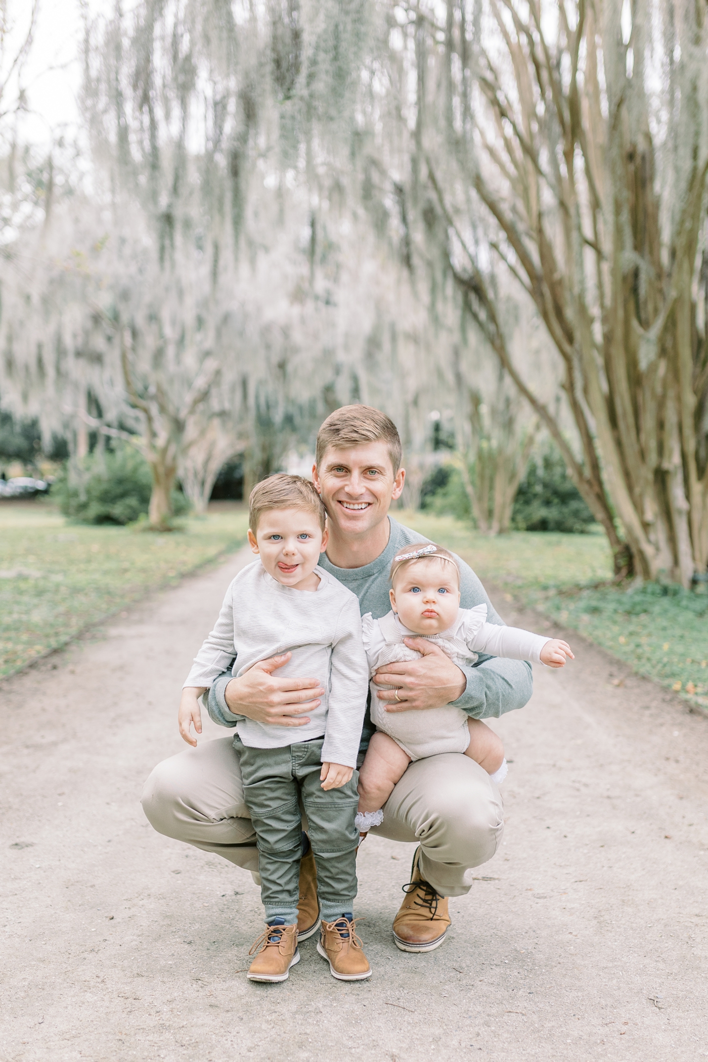 Dad with two kids during family session in Charleston SC. Photo by Caitlyn Motycka Photography.