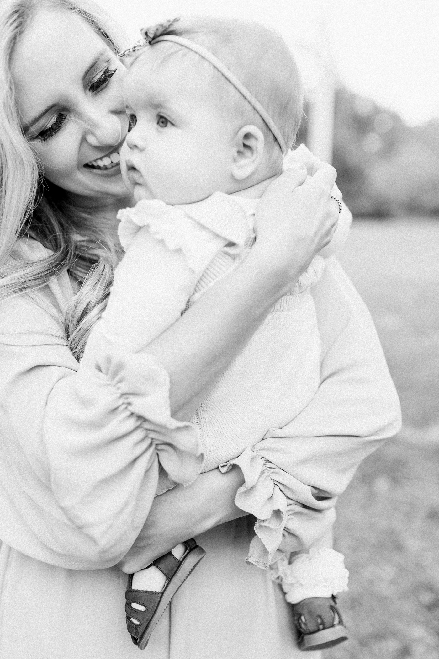 Black and white image of Mom cuddling baby girl. Photo by Caitlyn Motycka Photography.