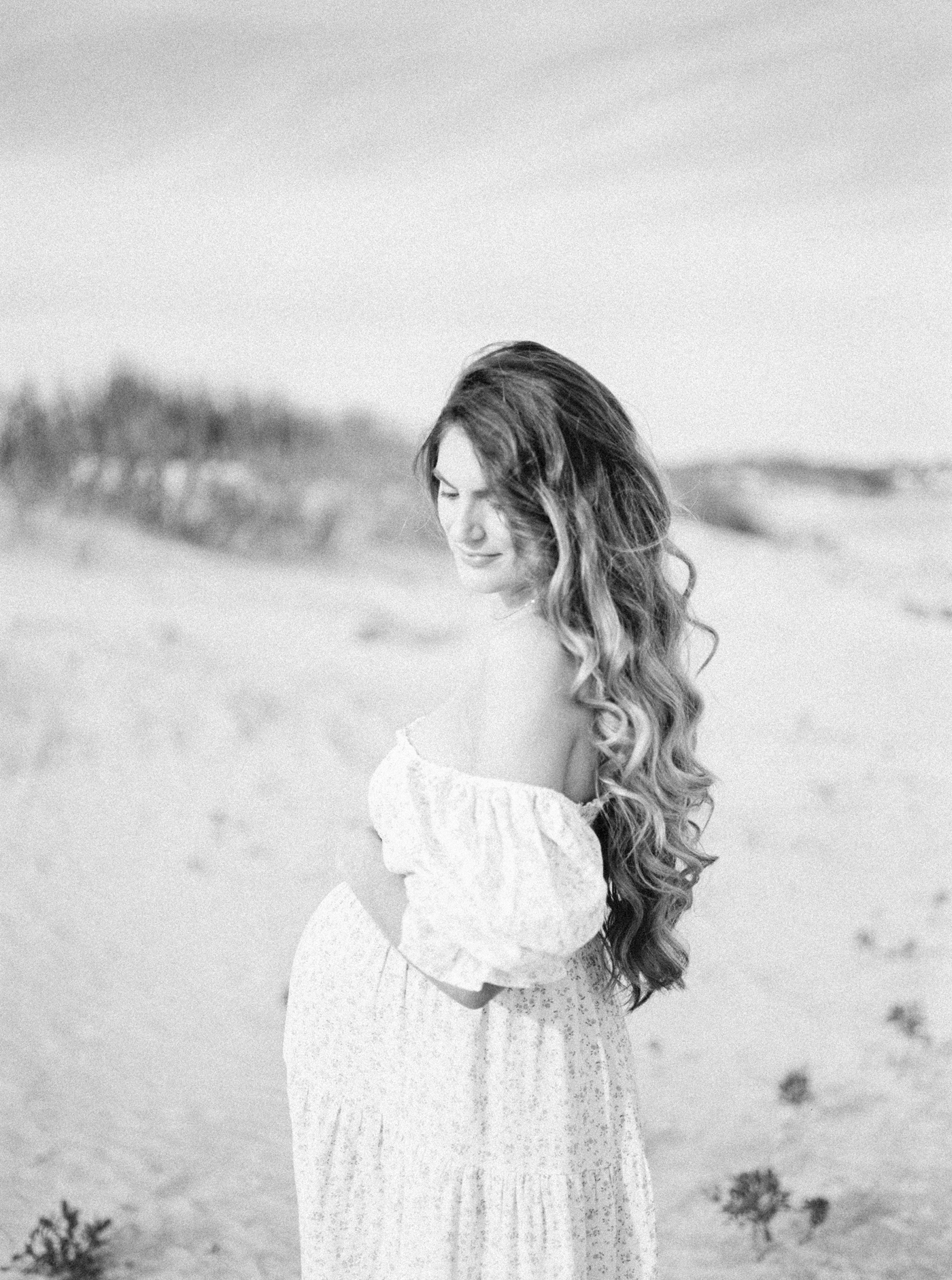 Black and white photo of mother on the beach | Photo by Caitlyn Motycka Photography.