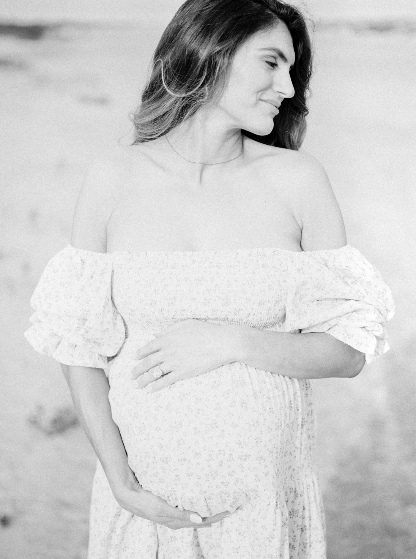 Black and white film image of mother on the beach | Photo by Caitlyn Motycka Photography. 
