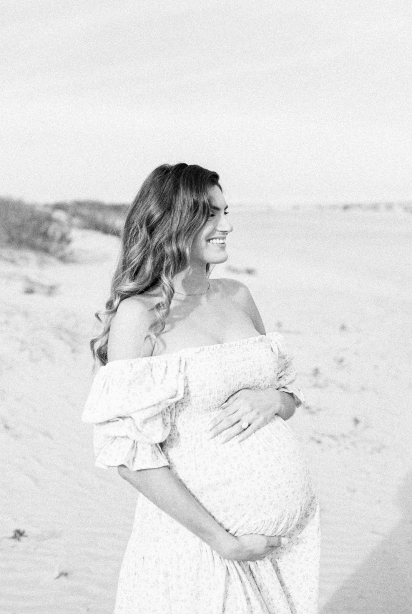 Black and white film photo of mother on the beach | Photo by Caitlyn Motycka Photography.