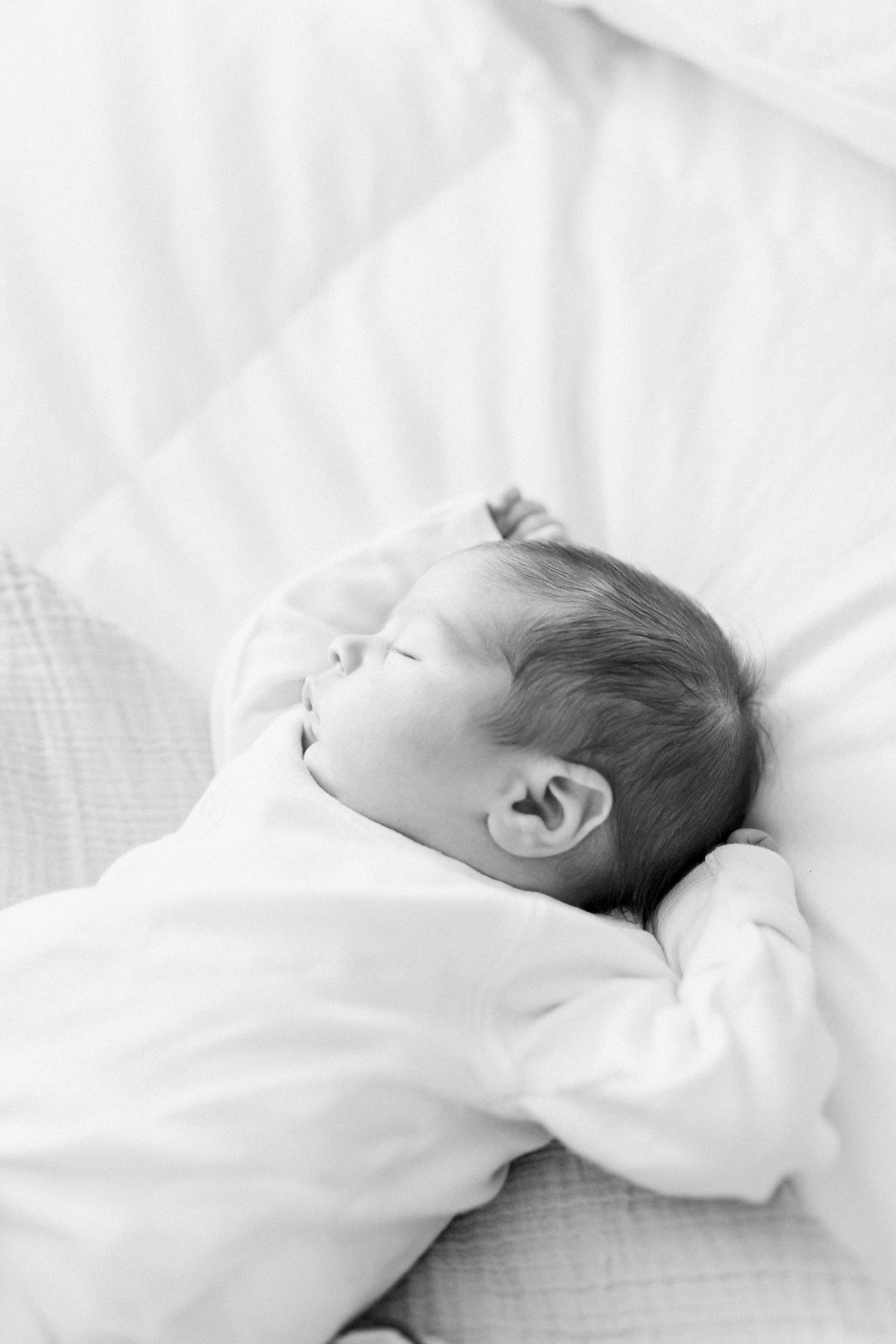 Black and white film photo of a sleeping newborn | Photo by Caitlyn Motycka Photography.