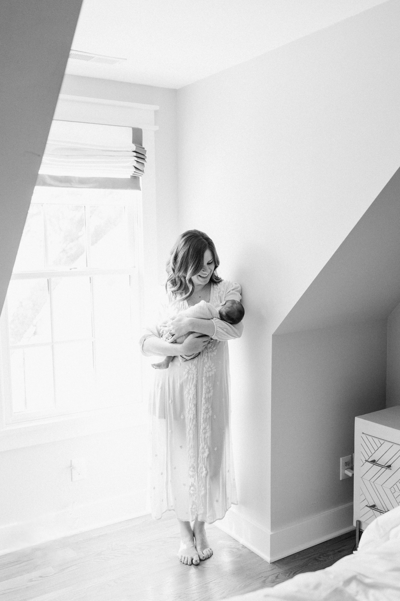 Mom holding baby during their in home newborn session | Photo by Caitlyn Motycka Photography.