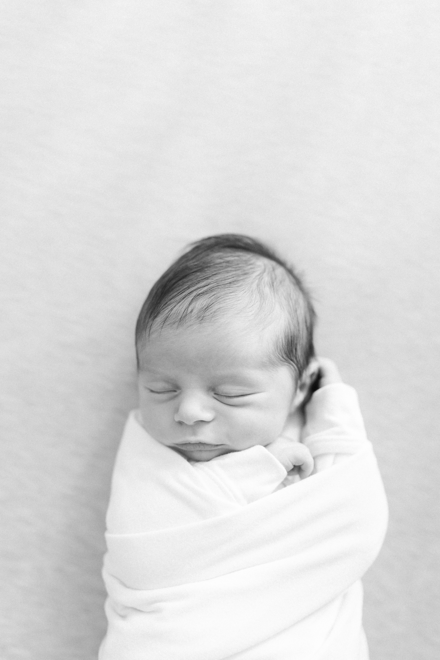 Black and white photo of sleeping newborn during her in home newborn session |Photo by Caitlyn Motycka Photography.