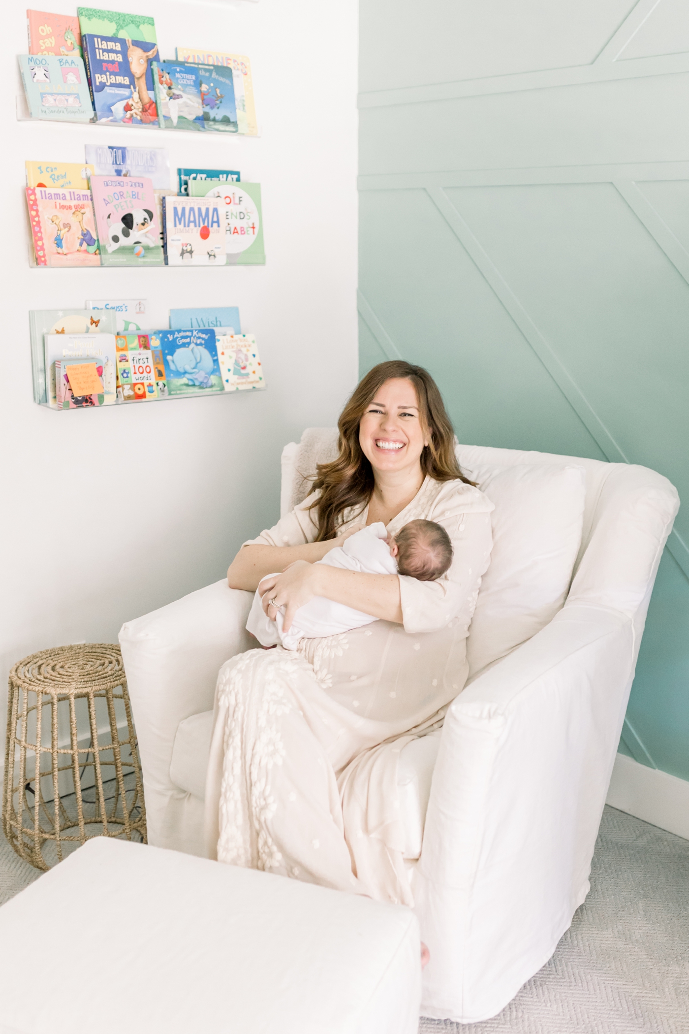 Mom smiling holding her baby during their in home newborn session | Photo by Caitlyn Motycka Photography.