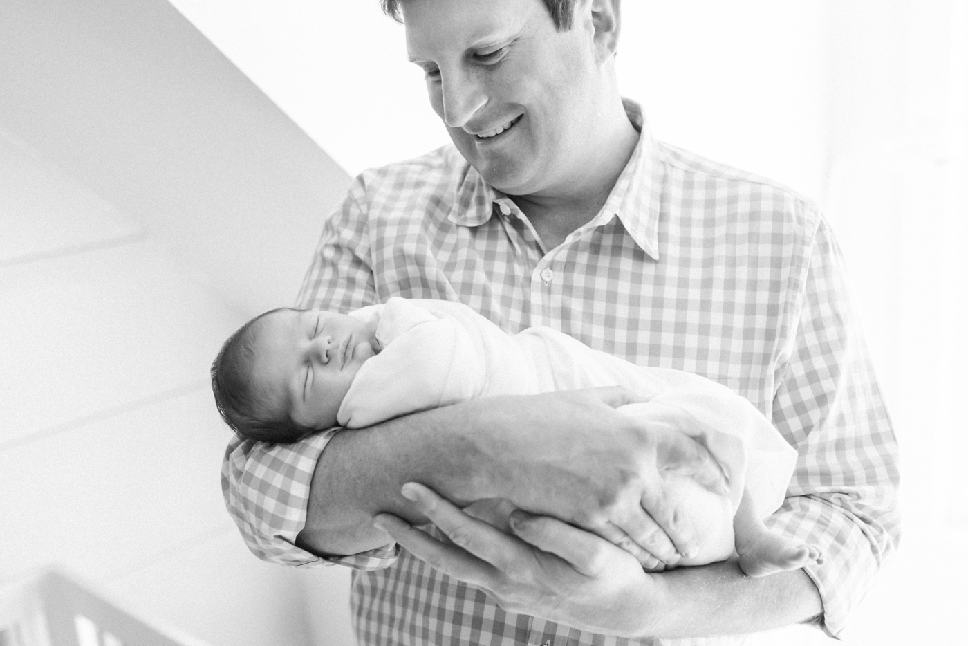 Black and white film photo of dad holding his new baby | Photo by Caitlyn Motycka Photography.