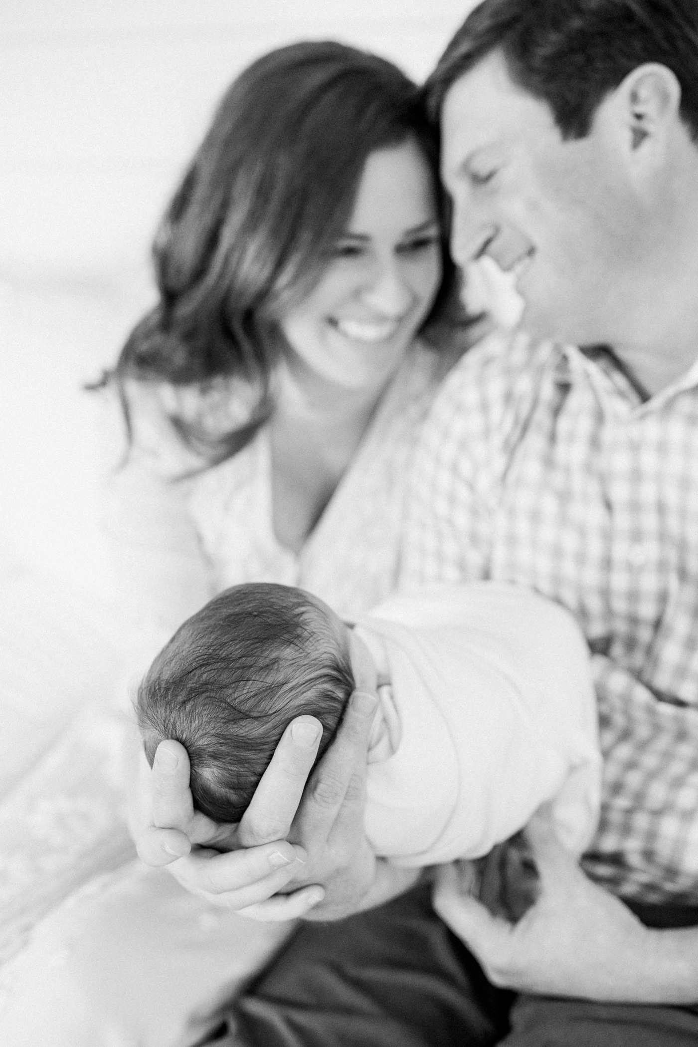 Mom and dad holding their new baby during their in home newborn session | Photo by Caitlyn Motycka Photography.