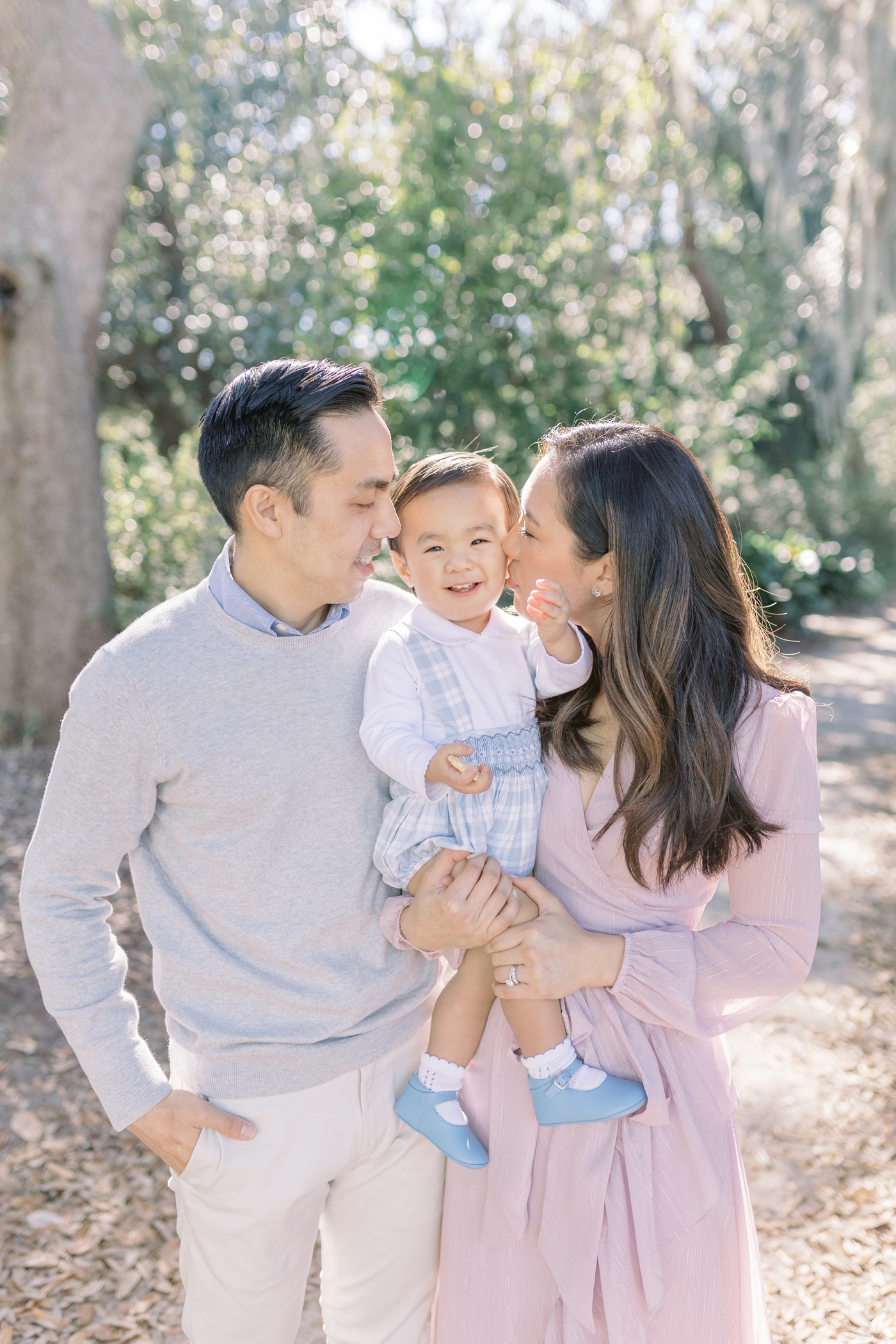 Mom and dad kissing toddler's cheeks during fall mini session | Photo by Caitlyn Motycka Photography