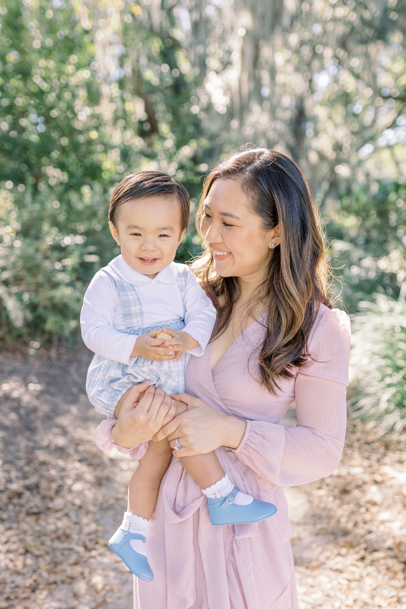 Mom and baby boy in blue smile for the camera | Photo by Caitlyn Motycka Photography