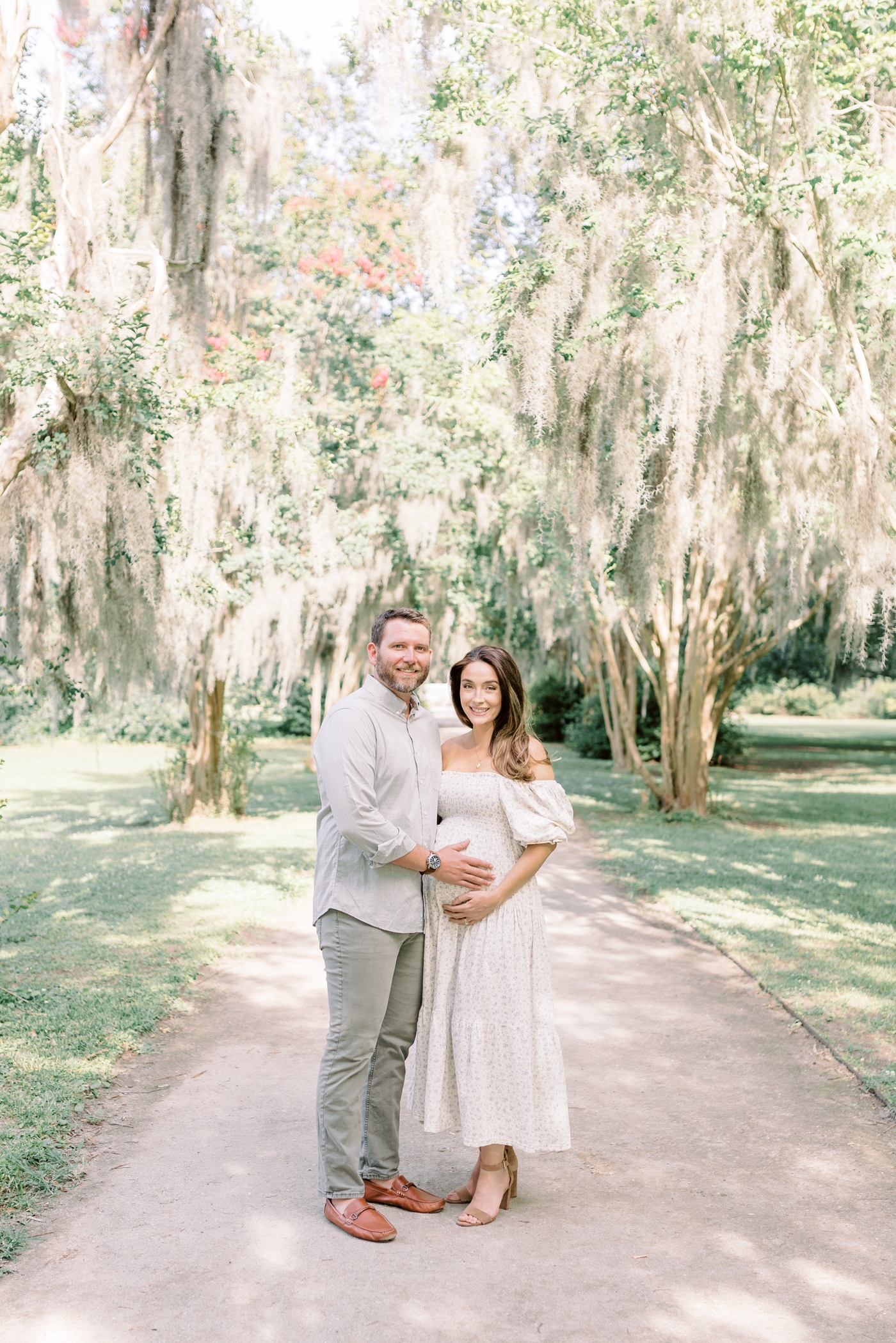 Mom and dad to be smiling in Hampton Park | Photo by Caitlyn Motycka Photography.