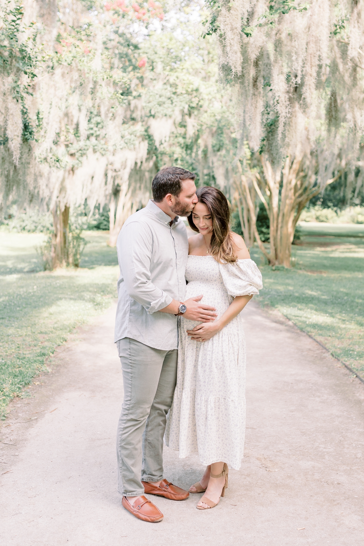 Dad to be kissing mom on the head | Photo by Caitlyn Motycka Photography.