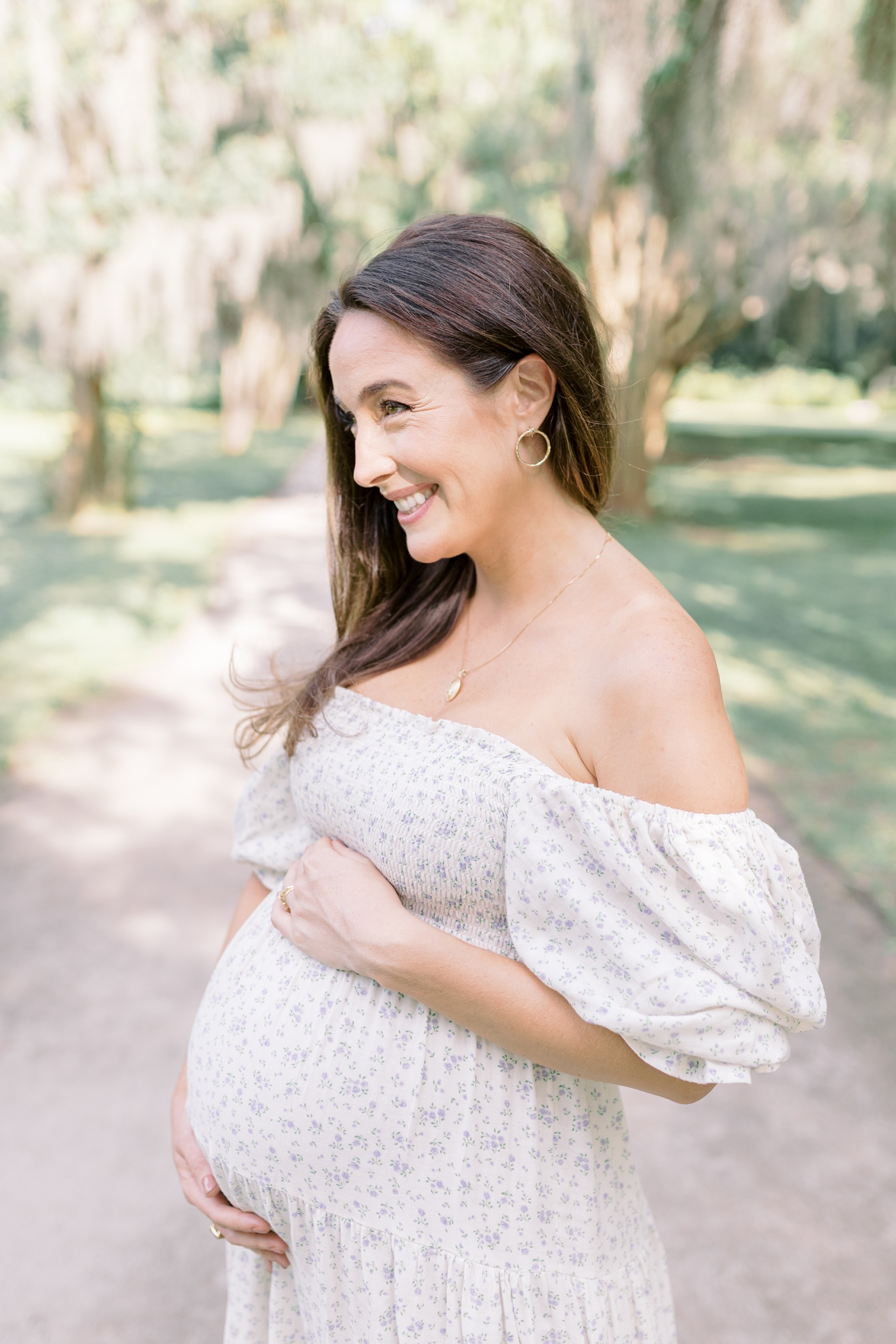 Mom to be smiling holding her belly | Photo by Caitlyn Motycka Photography.