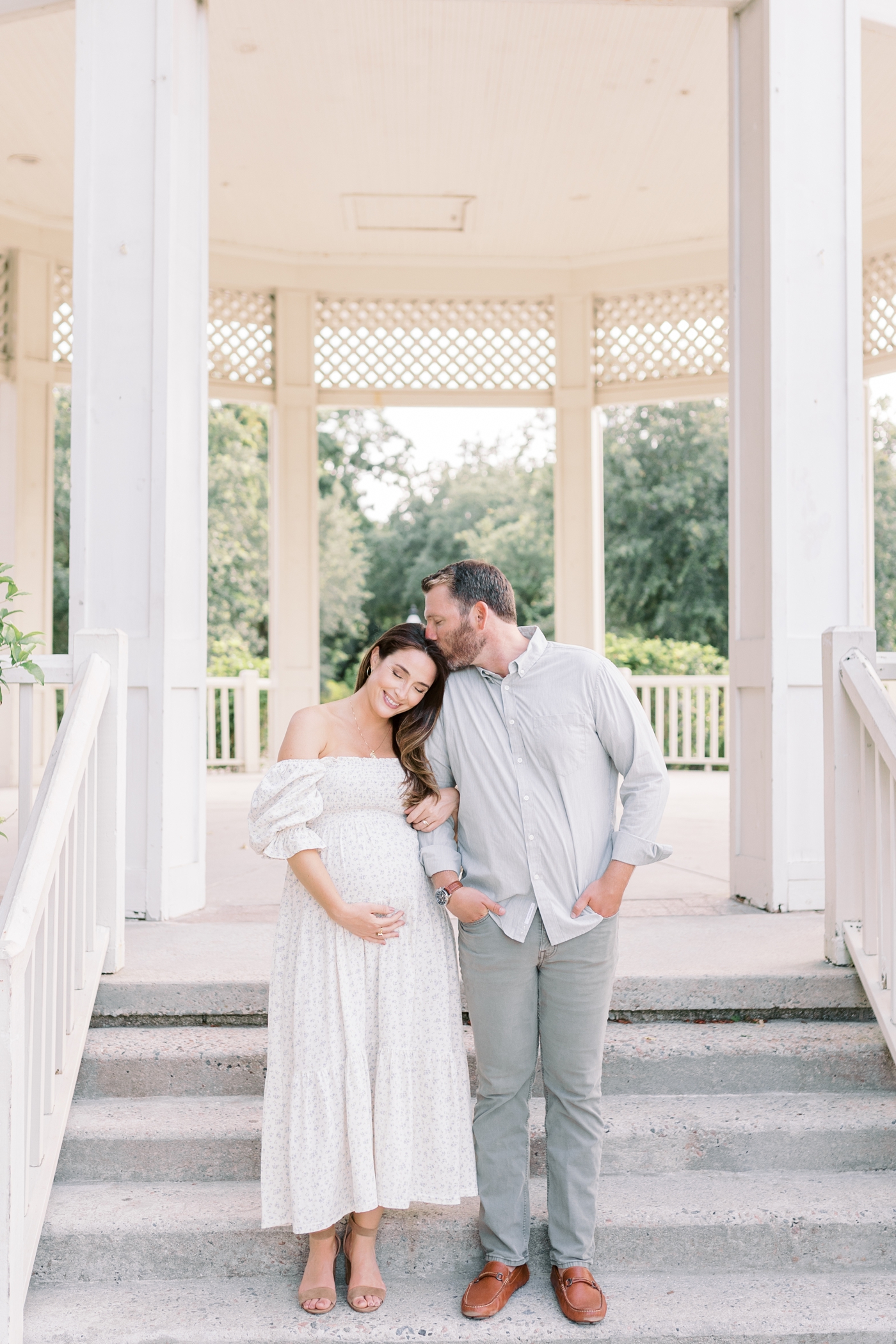 Mom and dad snuggling in a gazebo in Hampton Park | Photo by Caitlyn Motycka Photography.