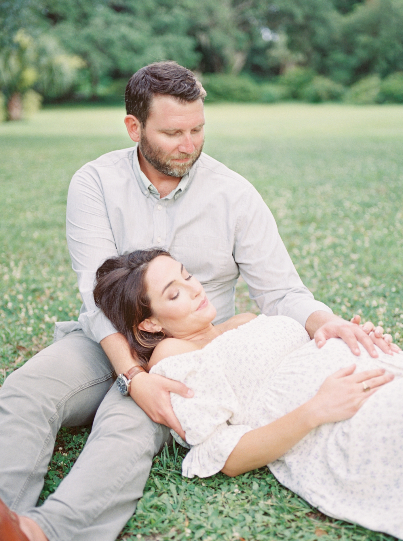 Mom to be laying with her head in her husband's lap | Photo by Caitlyn Motycka Photography.