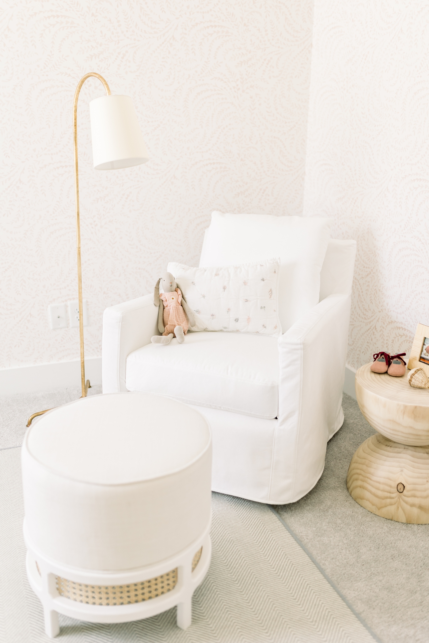 Glider with white slip cover in baby girl's nursery | Photo by Caitlyn Motycka Photography.