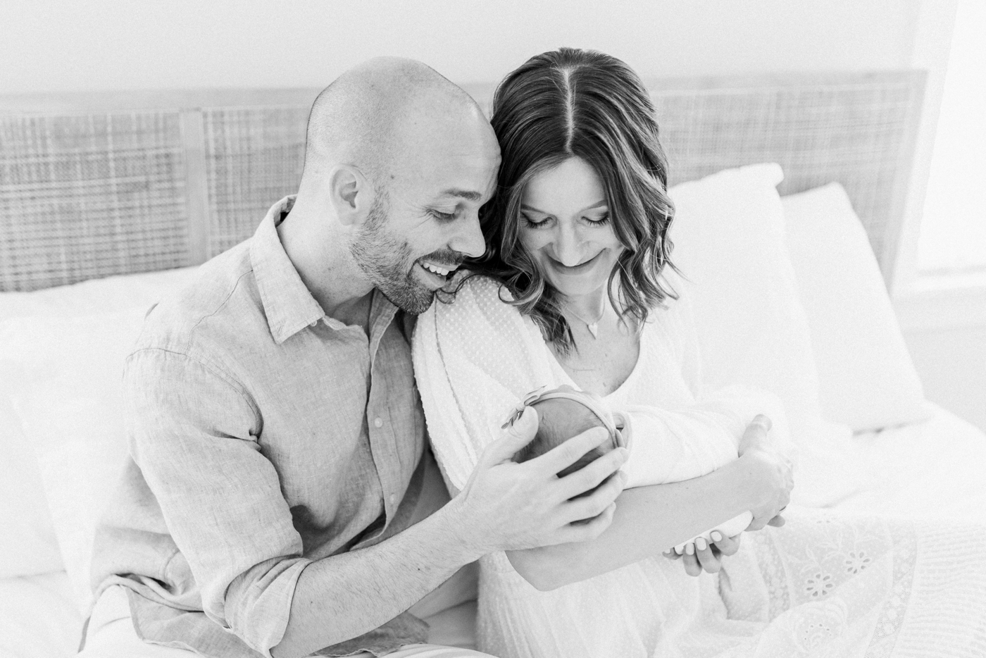 Black and white image of mom and dad holding newborn baby girl | Photo by Caitlyn Motycka Photography.