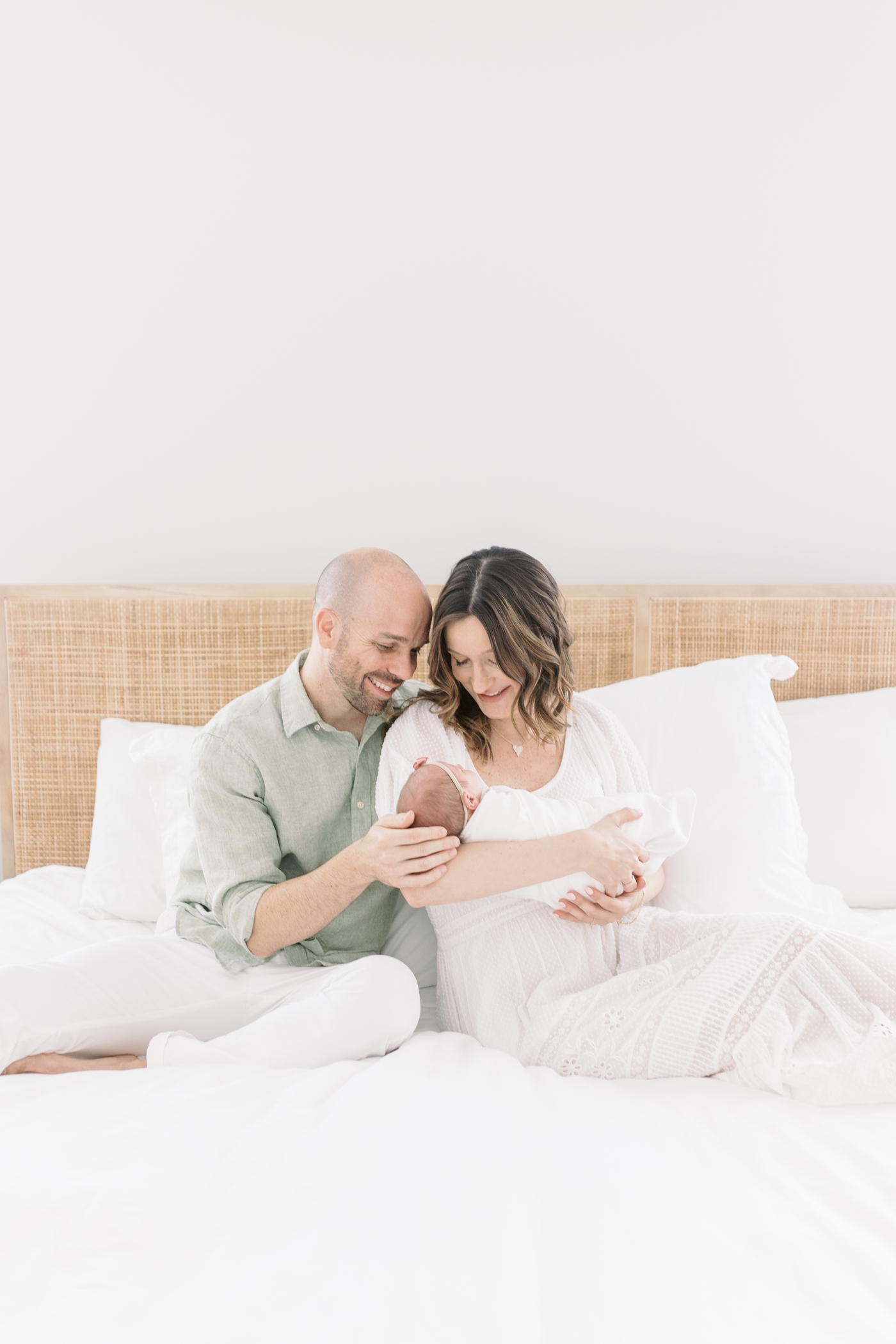 Mom and dad smiling holding baby girl | Photo by Caitlyn Motycka Photography.