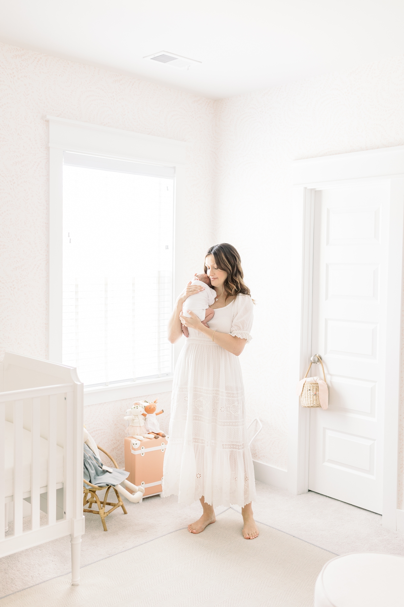 Mom holding her newborn in her nursery | Photo by Caitlyn Motycka Photography.