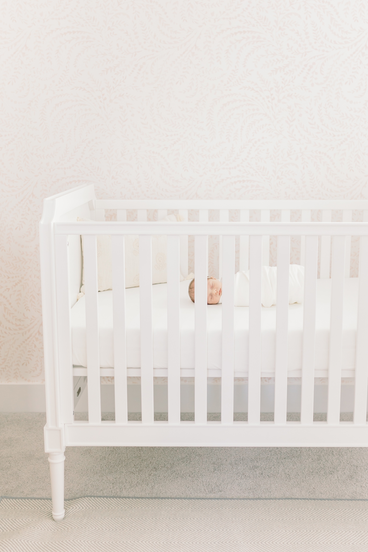 Baby girl sleeping in a white crib | Photo by Caitlyn Motycka Photography.