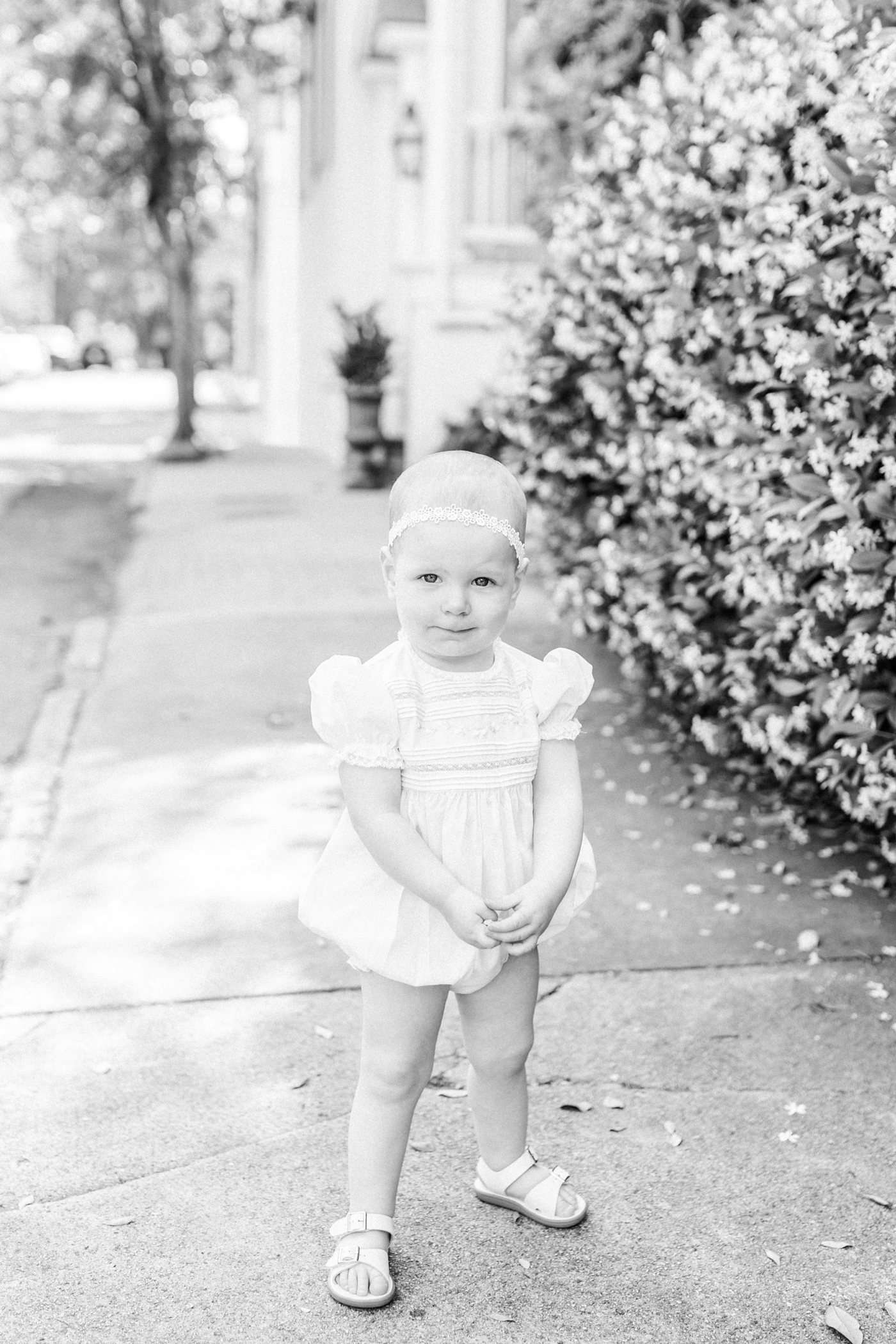 Black and white film photo of baby girl in front of blooming jasmine | Photo by Caitlyn Motycka Photography.