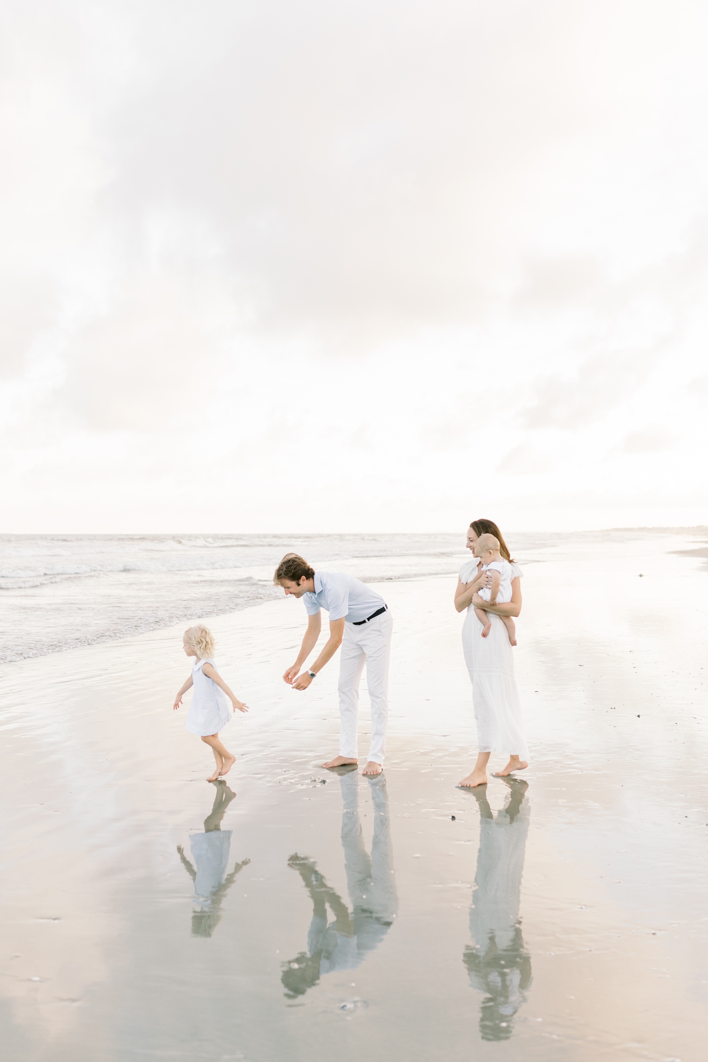 Family of four playing on the beach | Photo by Caitlyn Motycka Photography.