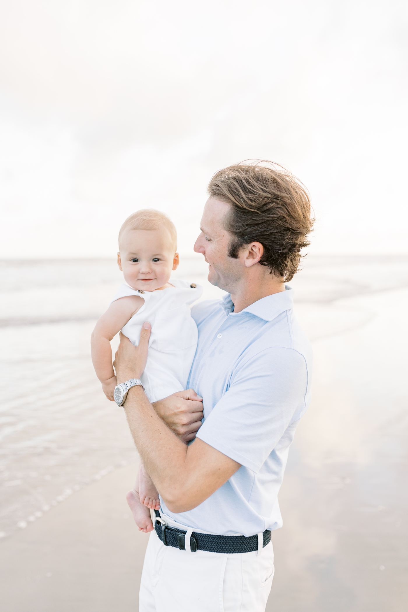Dad holding baby boy on the beach | Photo by Caitlyn Motycka Photography.