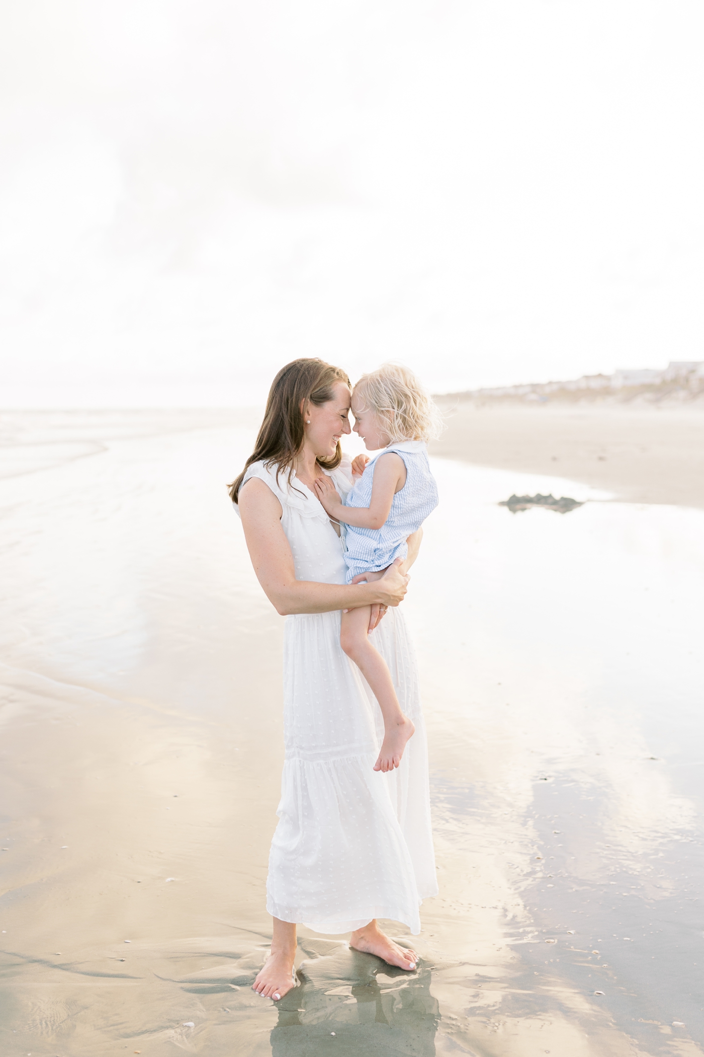 Mom snuggling with daughter on the beach | Photo by Caitlyn Motycka Photography.