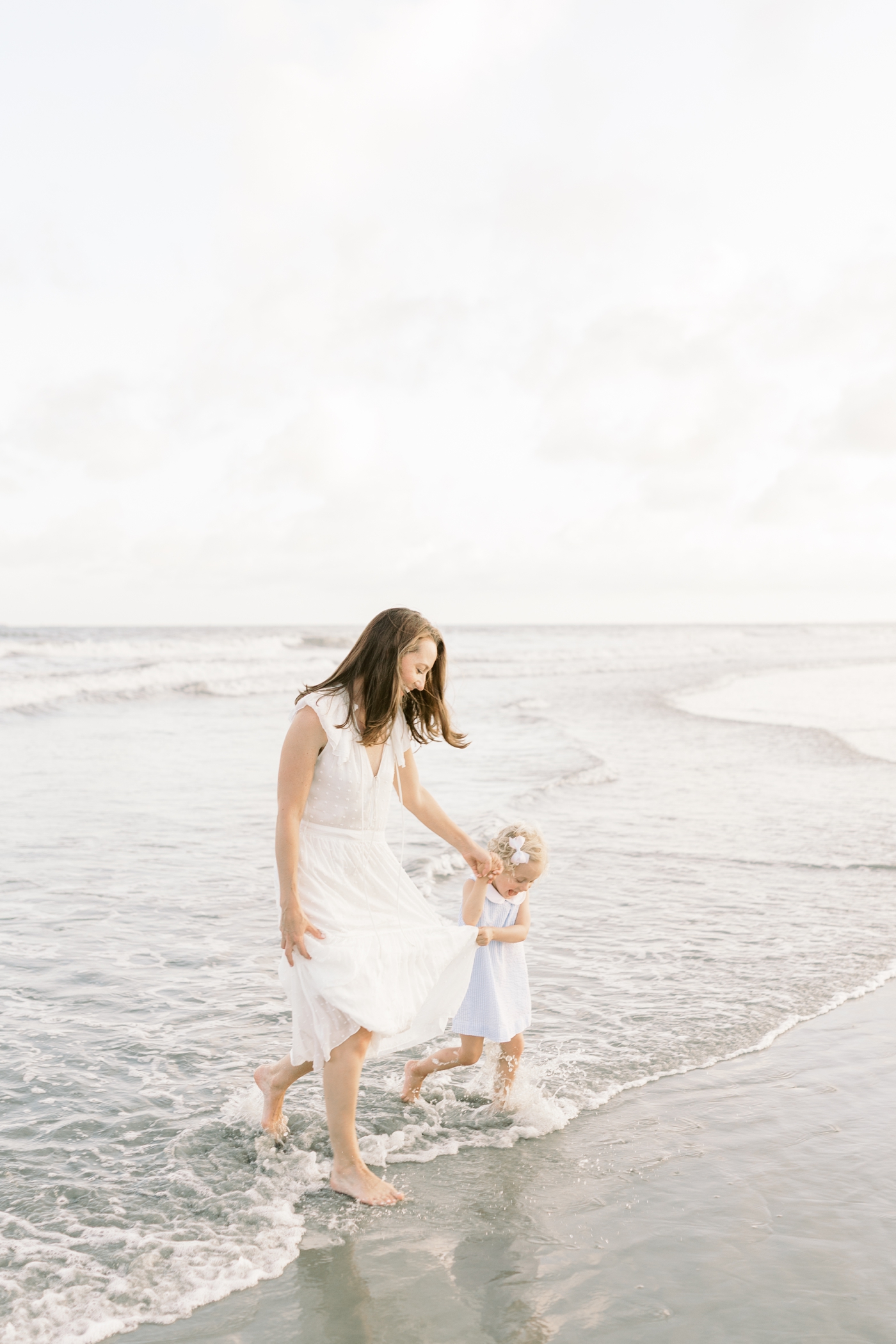 Mom and little girl running on the beach at Isle of Palms | Photo by Caitlyn Motycka Photography.