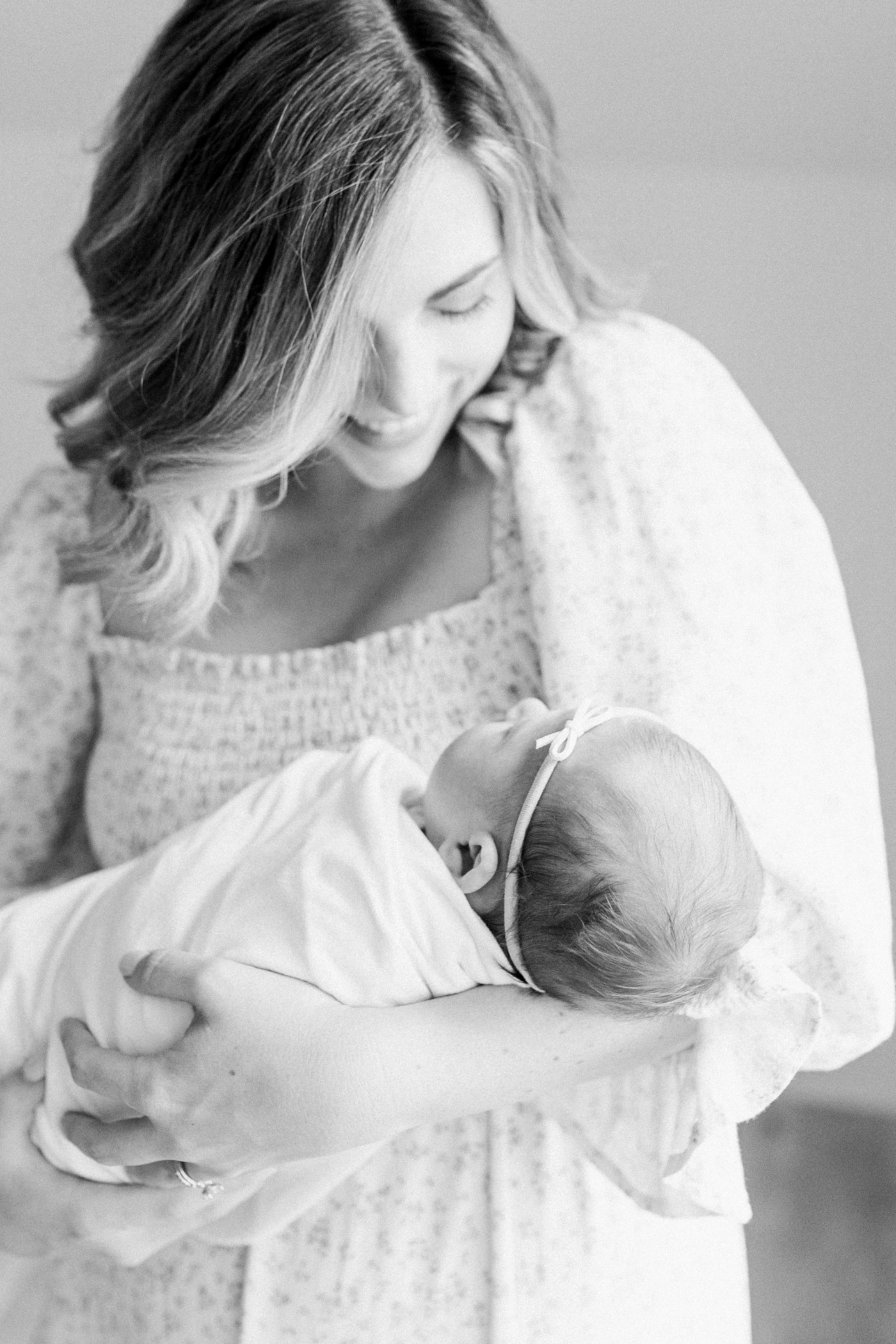 Black and white image of mom holding her new baby girl in their nursery | Photo by Caitlyn Motycka Photography.