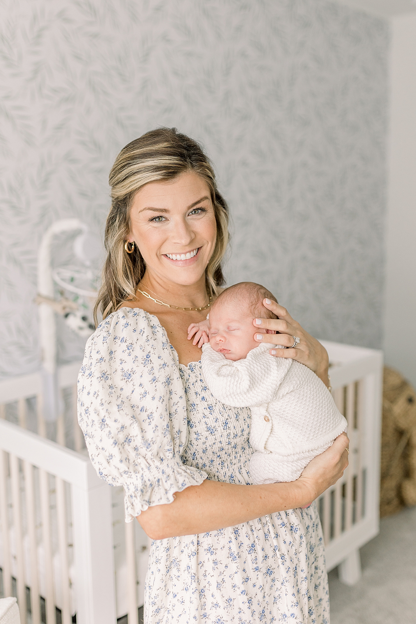 Mom smiling holding baby boy in his nursery | Photo by Caitlyn Motycka Photography