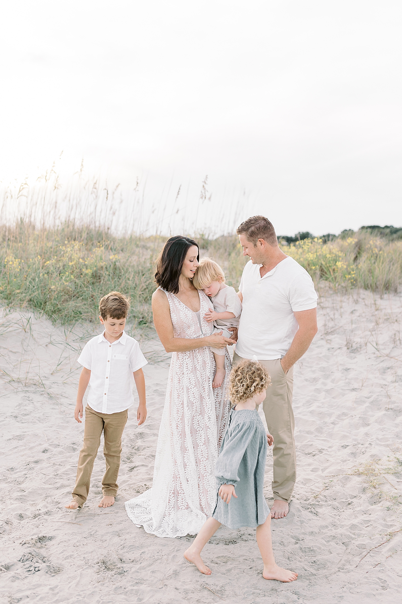 Family snuggling together during fall family session at beach | Photo by Caitlyn Motycka Photography