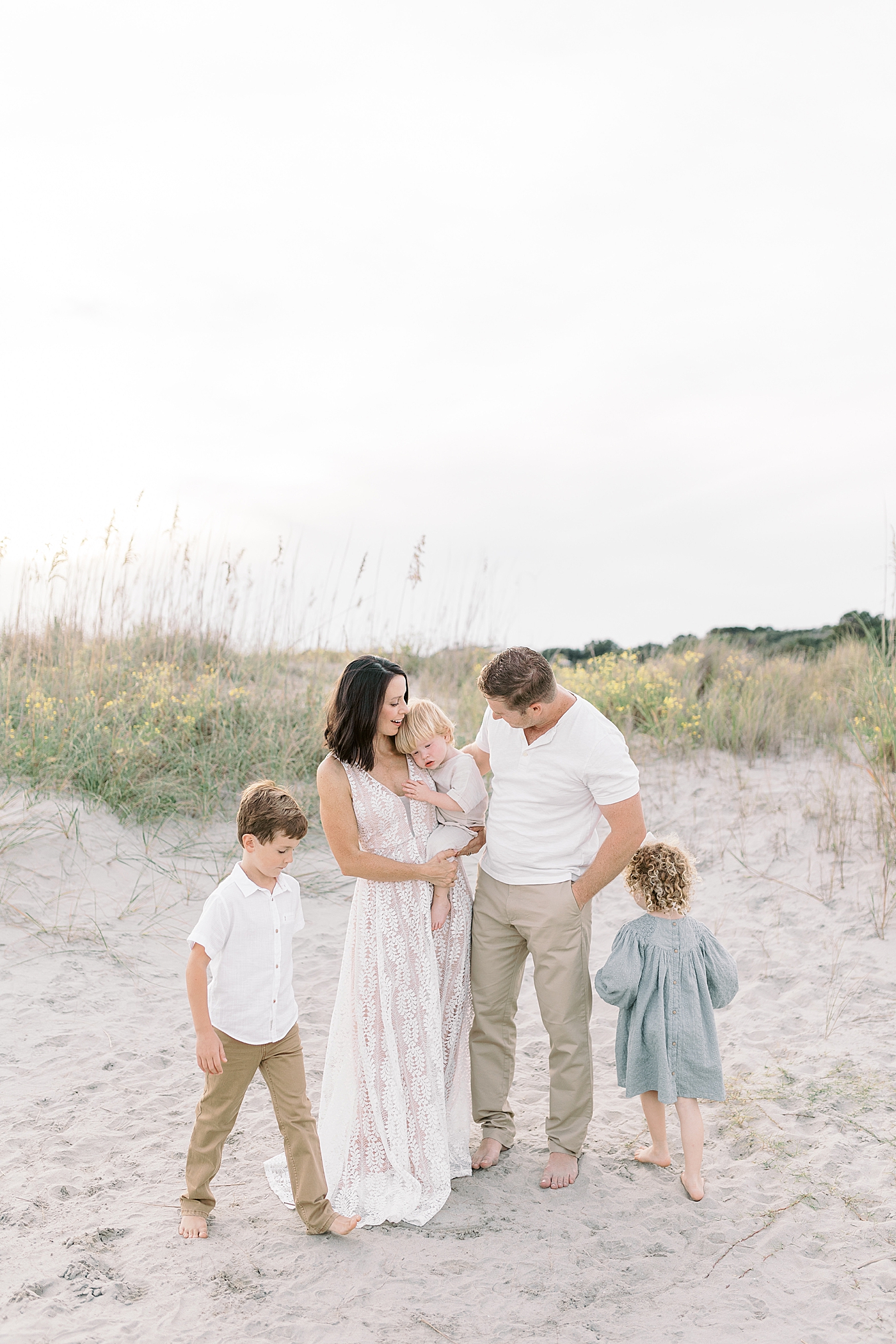 Family snuggling together during fall family session at beach | Photo by Caitlyn Motycka Photography