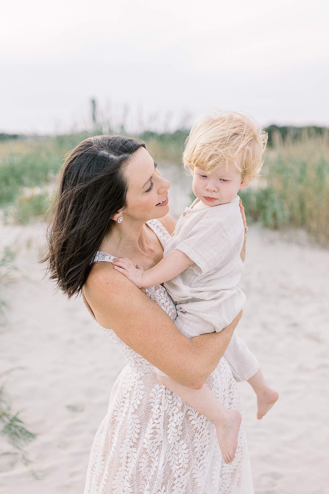 Mom holding her baby boy on the beach | Photo by Caitlyn Motycka Photography