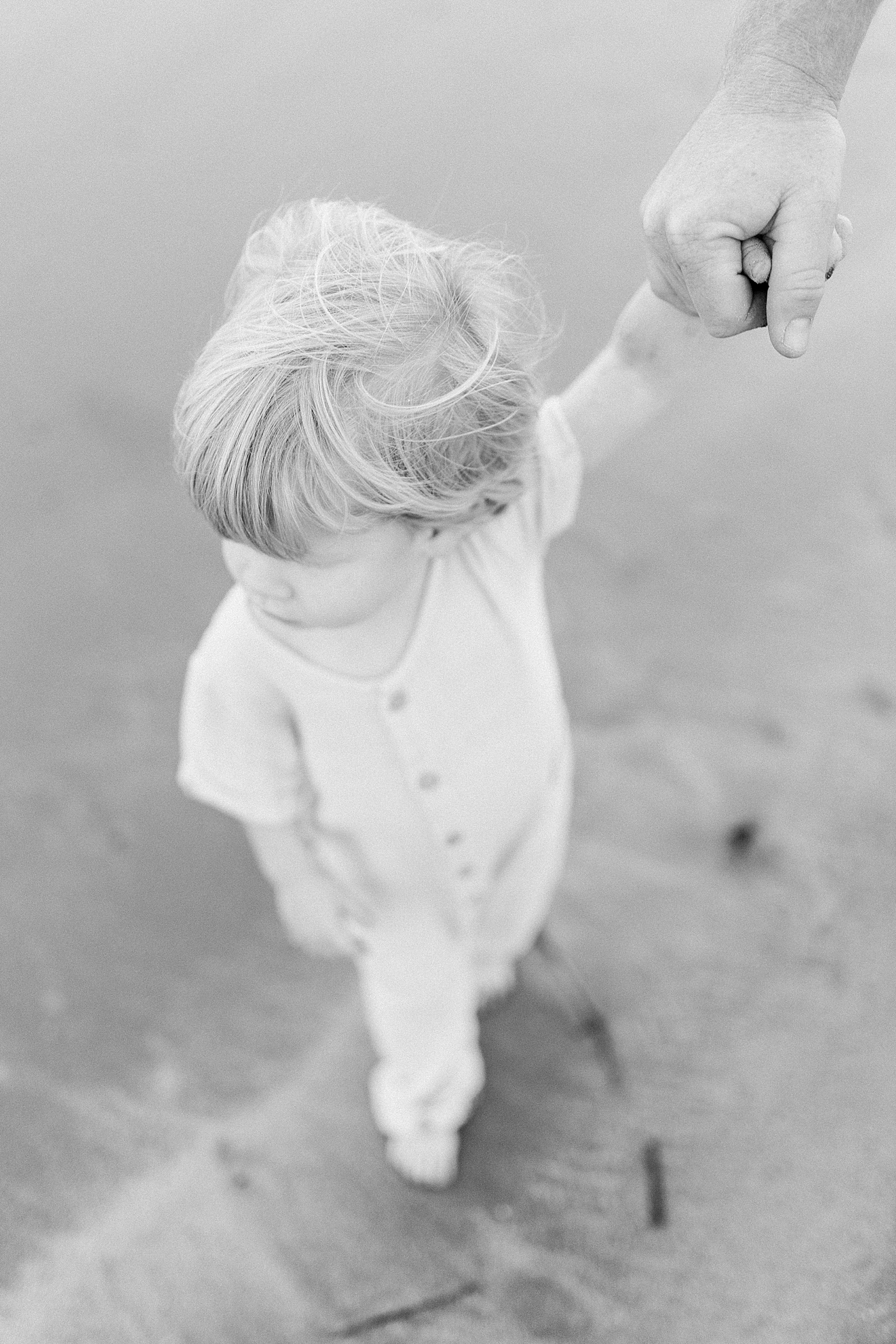 Black and white photo of baby boy on the beach | Photo by Caitlyn Motycka Photography
