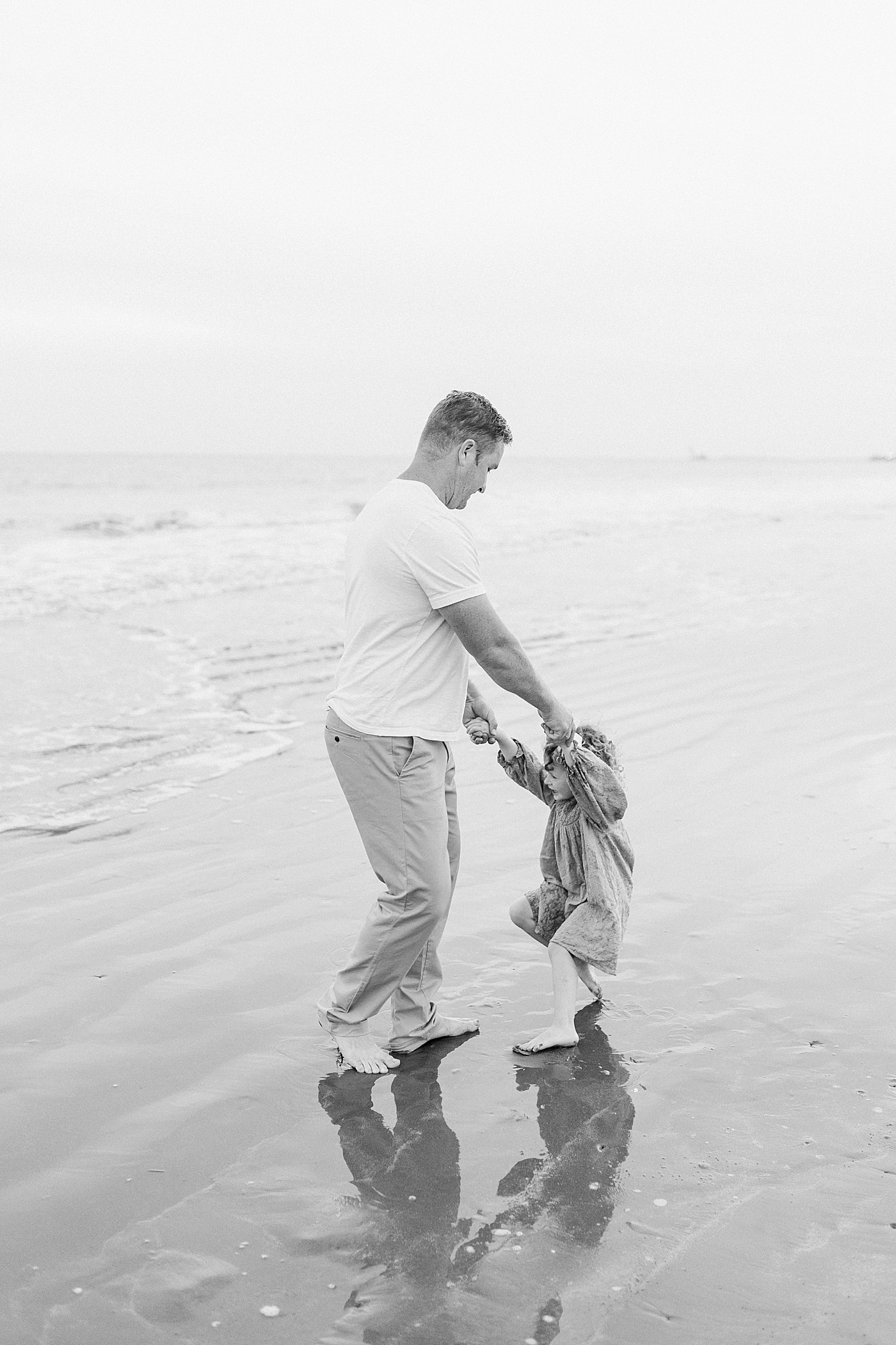 Daddy playing with daughter during fall family session at beach | Photo by Caitlyn Motycka Photography