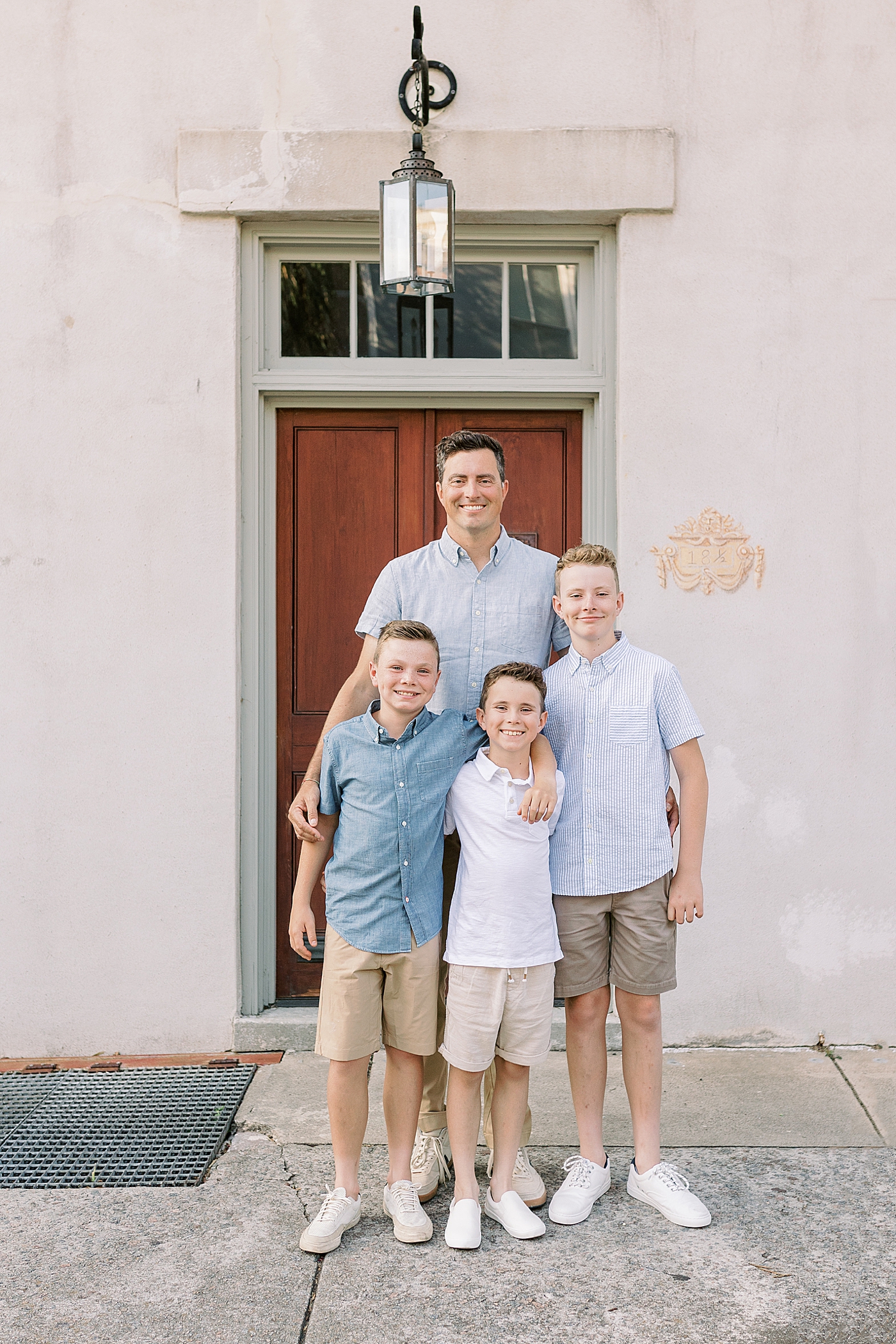 Dad smiling with his three sons | Photo by Caitlyn Motycka Photography