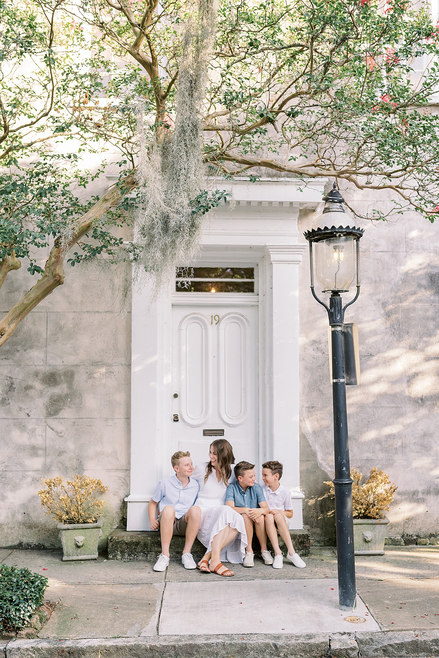 Mom sitting with her sons on a stoop in Charleston | Photo by Caitlyn Motycka Photography