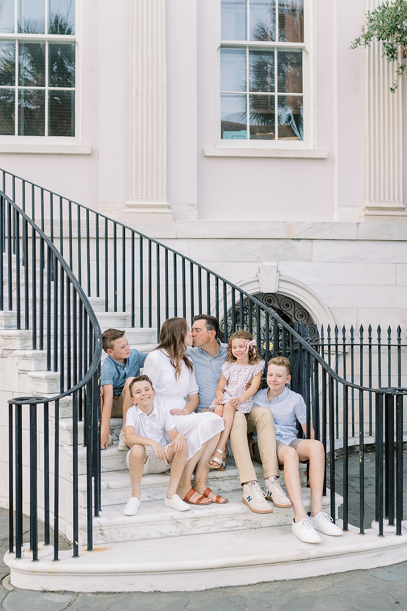 Family of six sitting on steps in downtown Charleston | Photo by Caitlyn Motycka