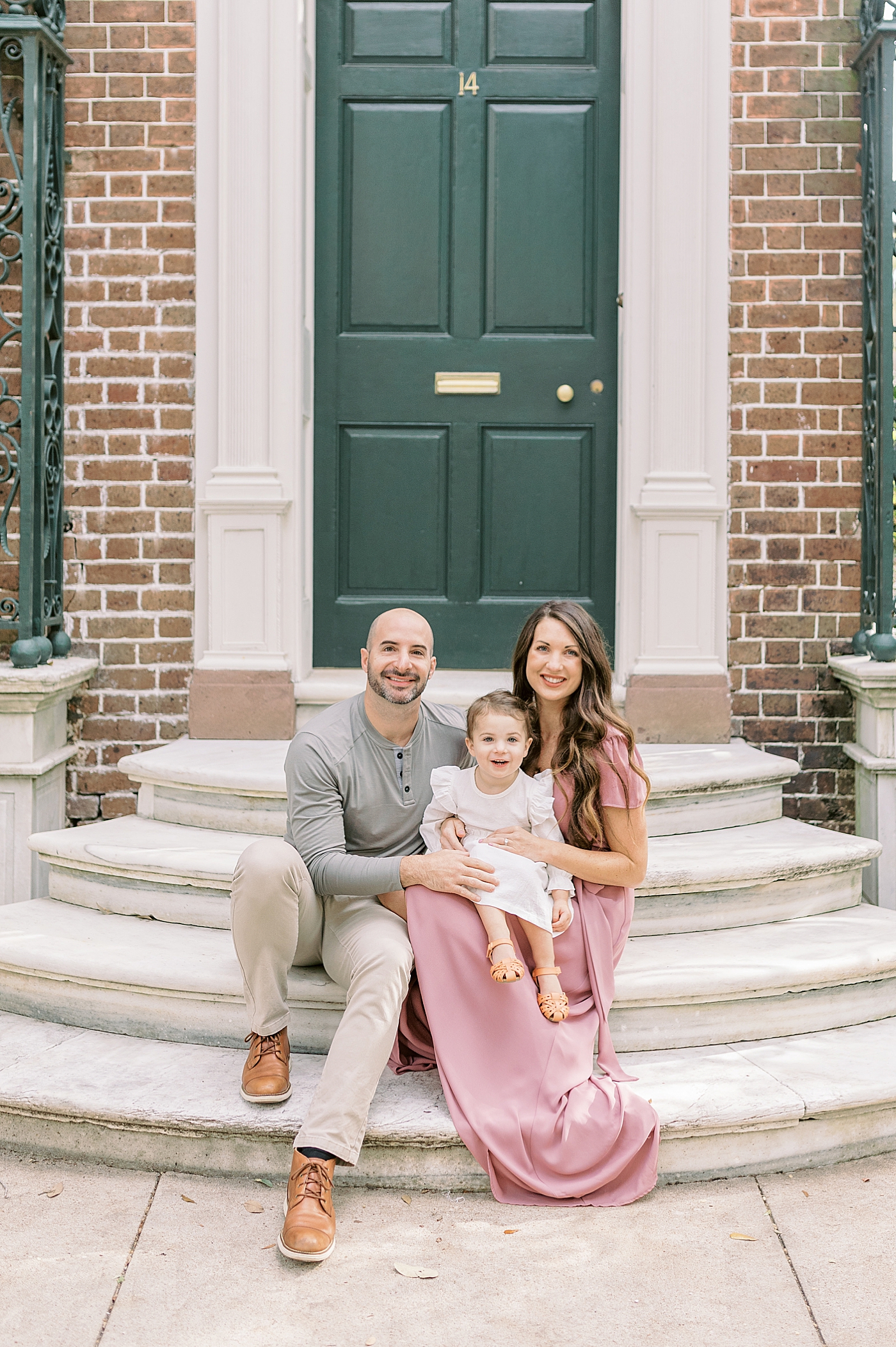 Family of three sitting on a stoop in Charleston | Photo by Caitlyn Motycka Photography
