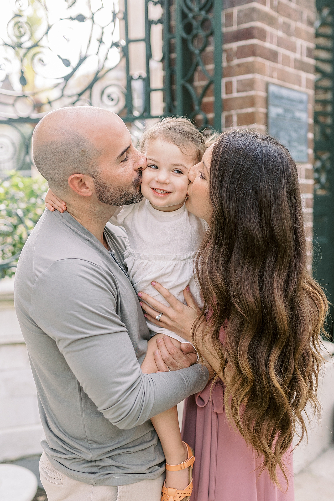 Mom and dad kissing their toddler during their Fall Family Mini Session | Photo by Caitlyn Motycka Photography
