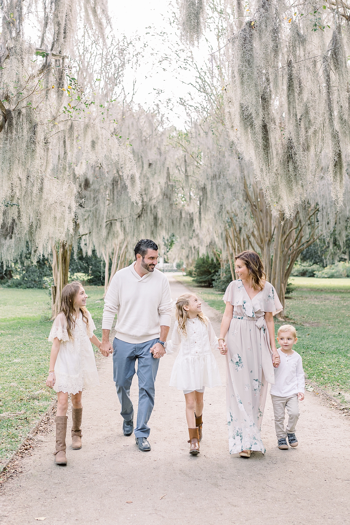Family of five walking on a path during their Fall Family Photos in Charleston | Photo by Caitlyn Motycka Photography
