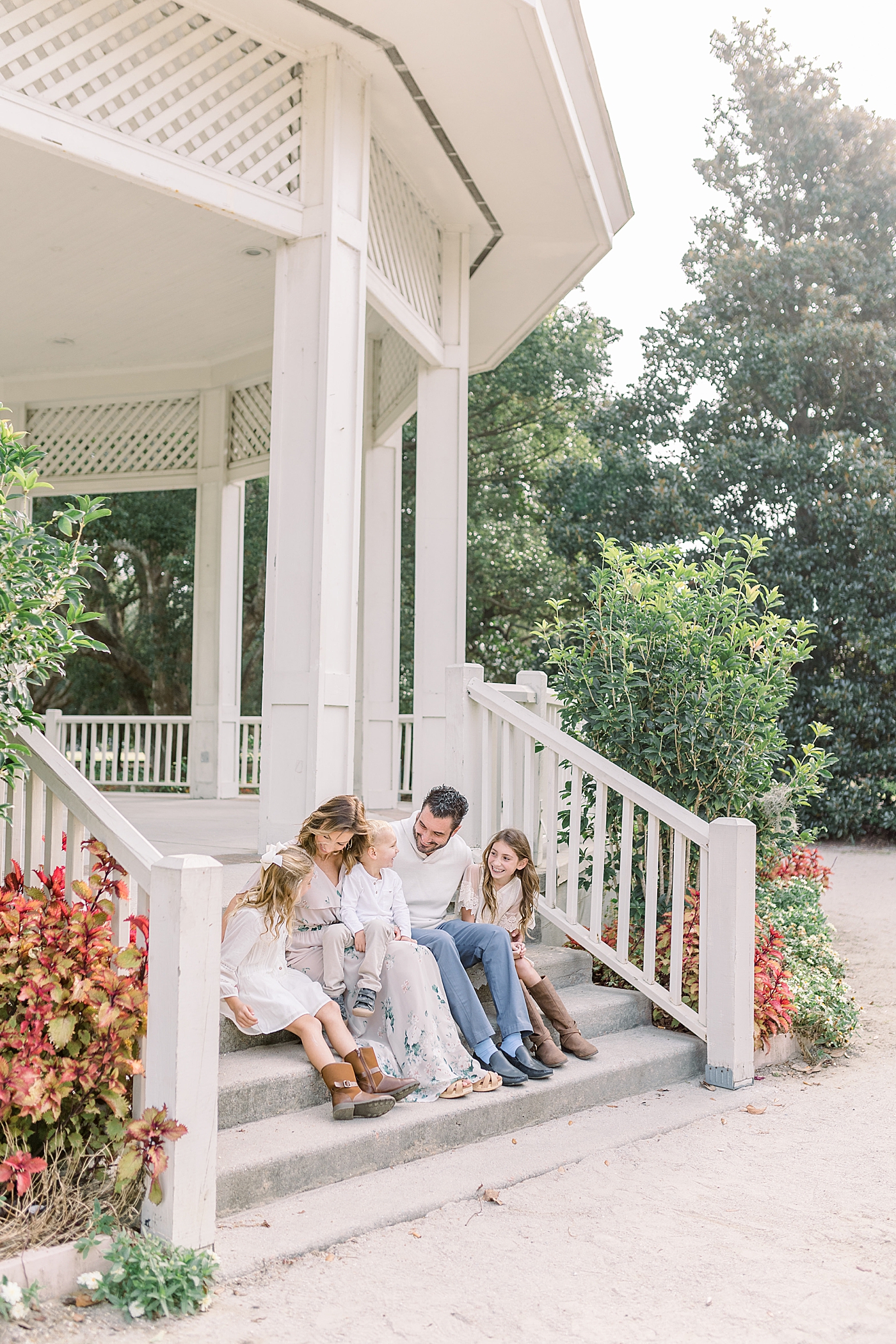 Mom and dad sitting with their three kids during their Fall Family Photos in Charleston | Photo by Caitlyn Motycka Photography