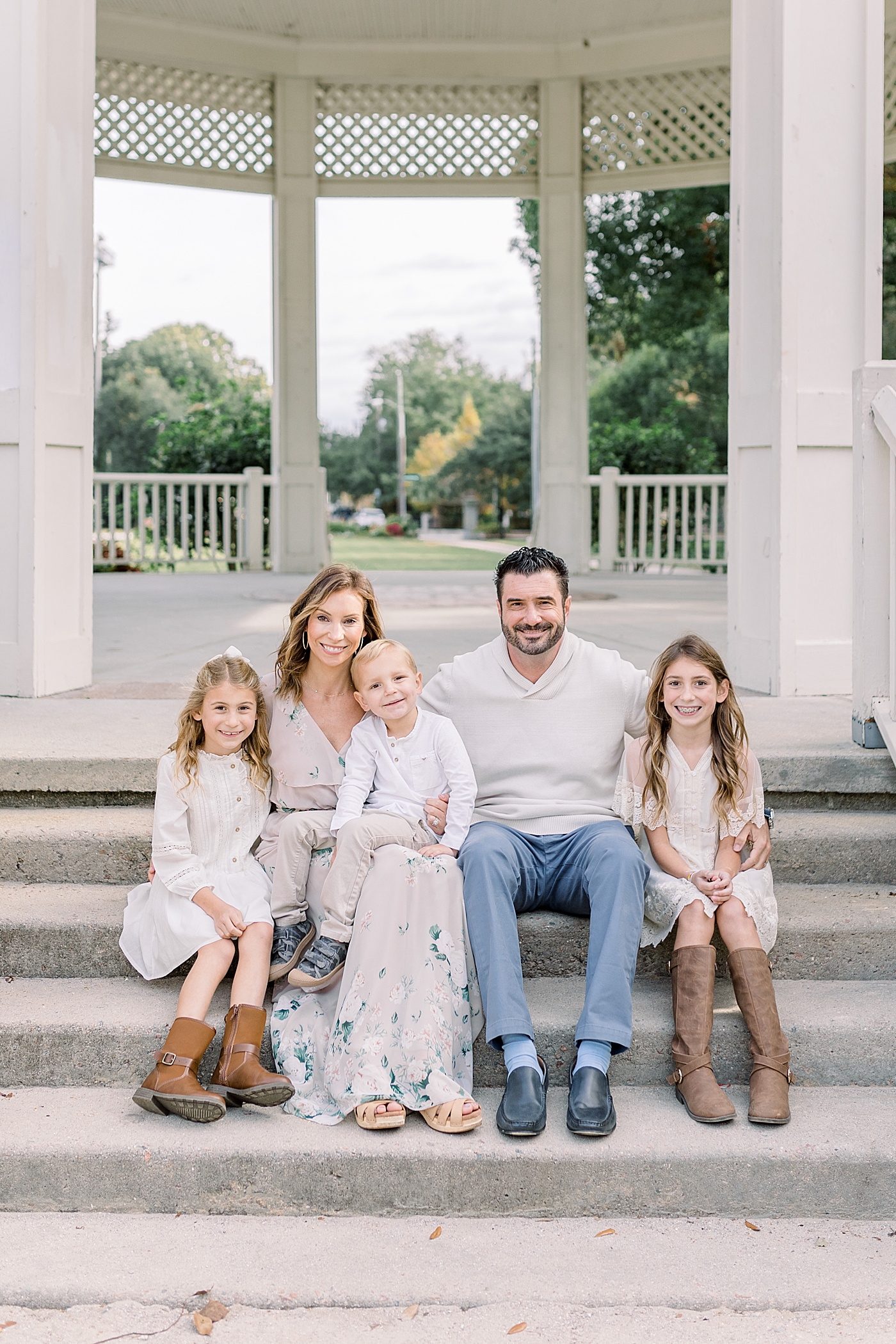 Mom and dad sitting with their three little ones during their Fall Family Photos in Charleston | Photo by Caitlyn Motycka Photography