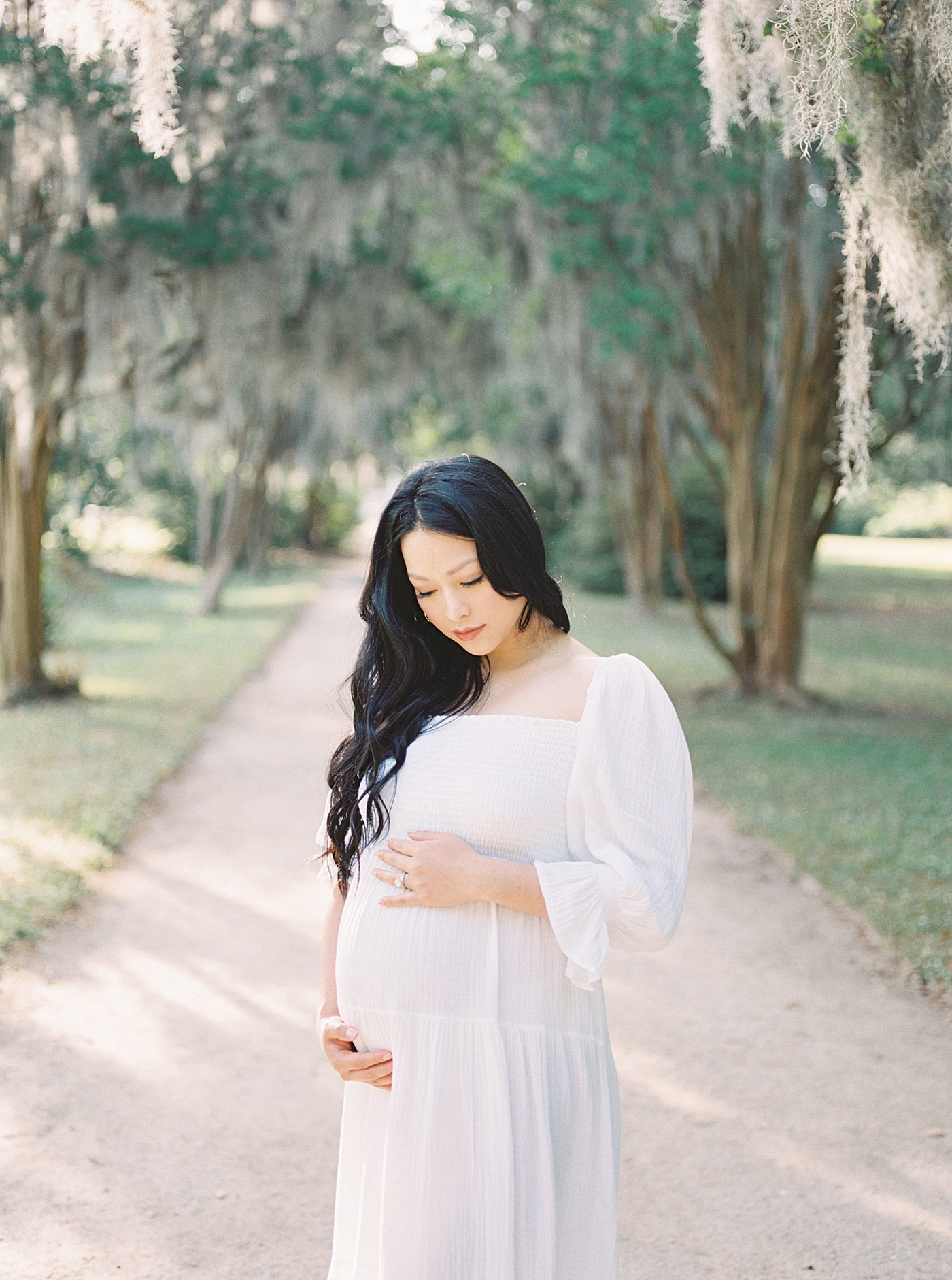 Mother to be in a white dress in Hampton Park | Photo by Caitlyn Motycka Photography