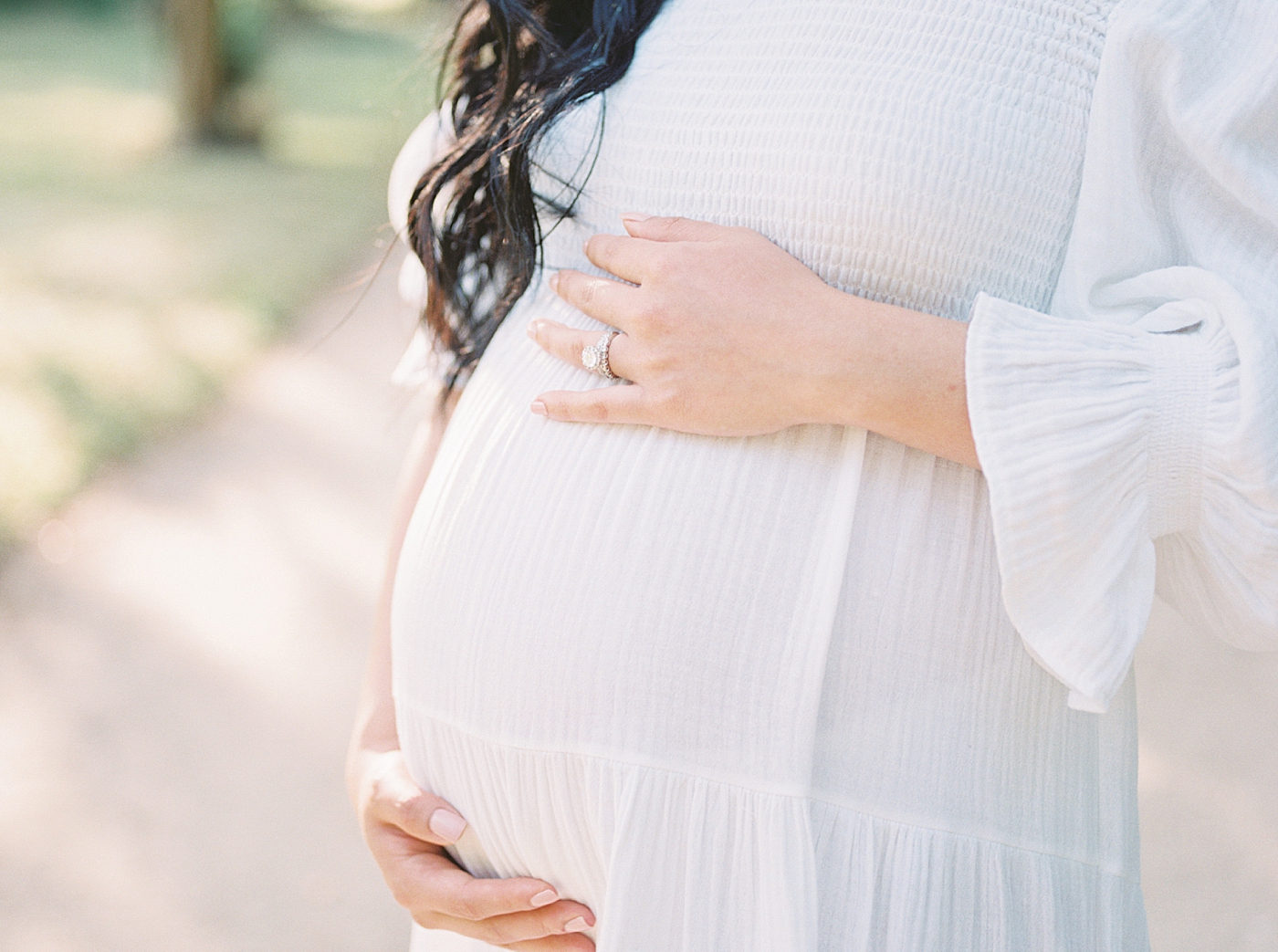 Detail of mother to be holding her belly | Photo by Caitlyn Motycka Photography