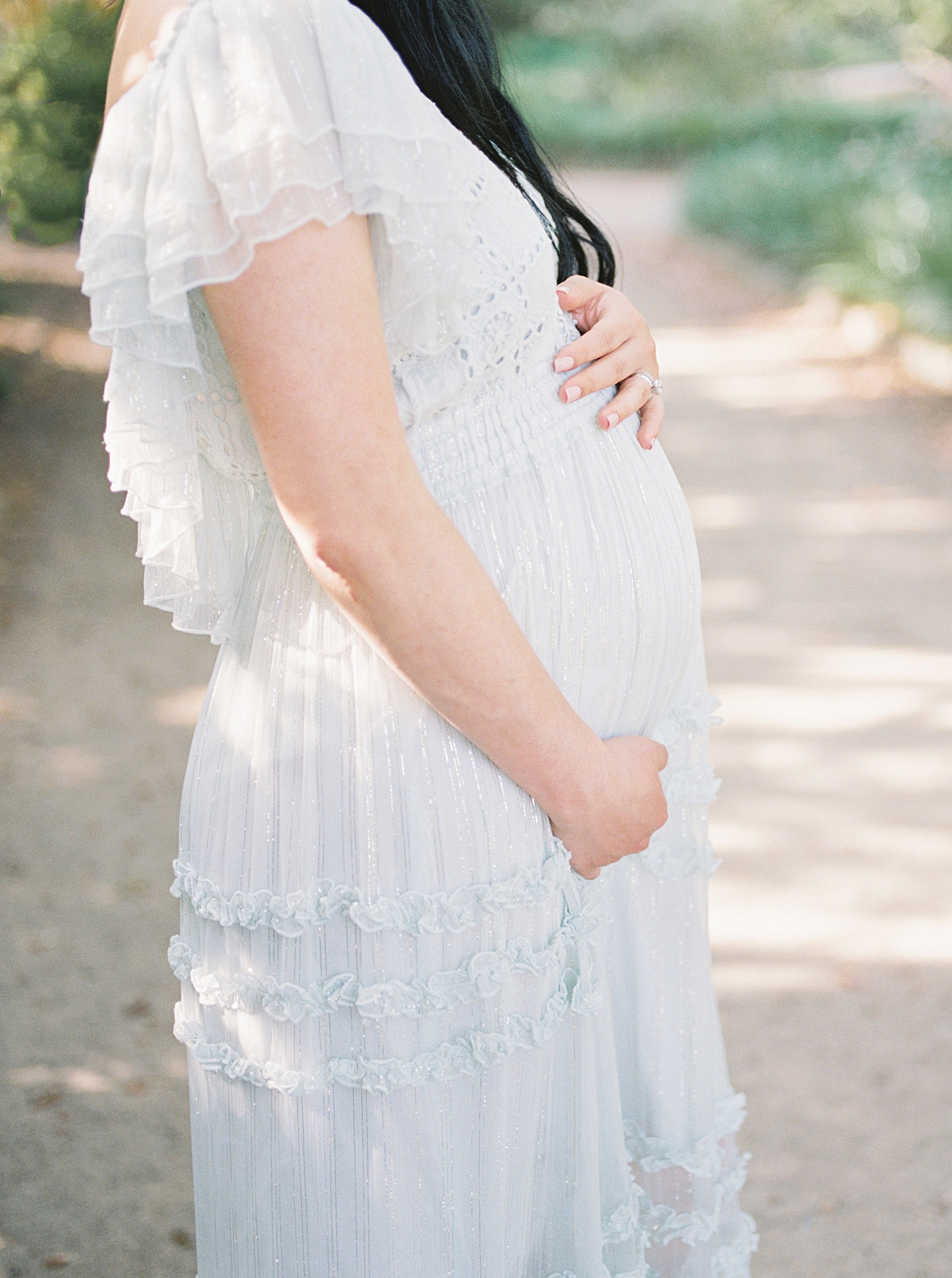Mother to be in ruffled dress during her maternity photos in Charleston | Photo by Caitlyn Motycka Photography