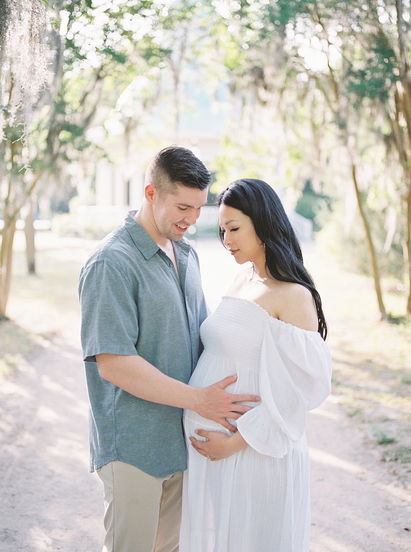 Couple snuggling together during their maternity photos in Charleston | Photo by Caitlyn Motycka Photography